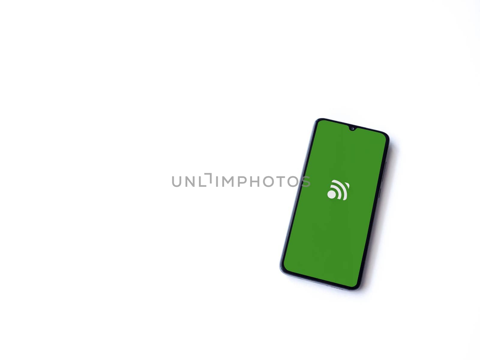 Lod, Israel - July 16,2023: Unified Remote app launch screen on smartphone on white background. Top view flat lay with copy space.