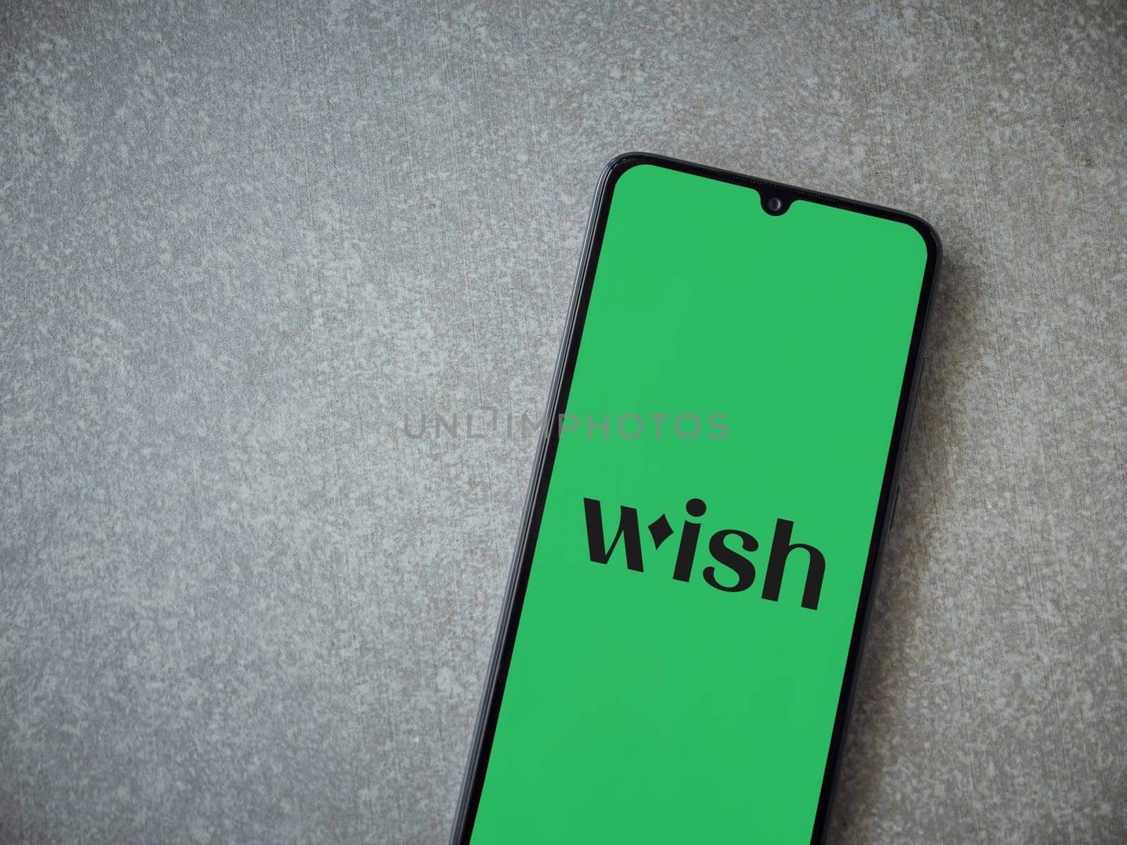 Lod, Israel - July 16,2023: Wish app launch screen on smartphone on ceramic stone background. Top view flat lay with copy space.