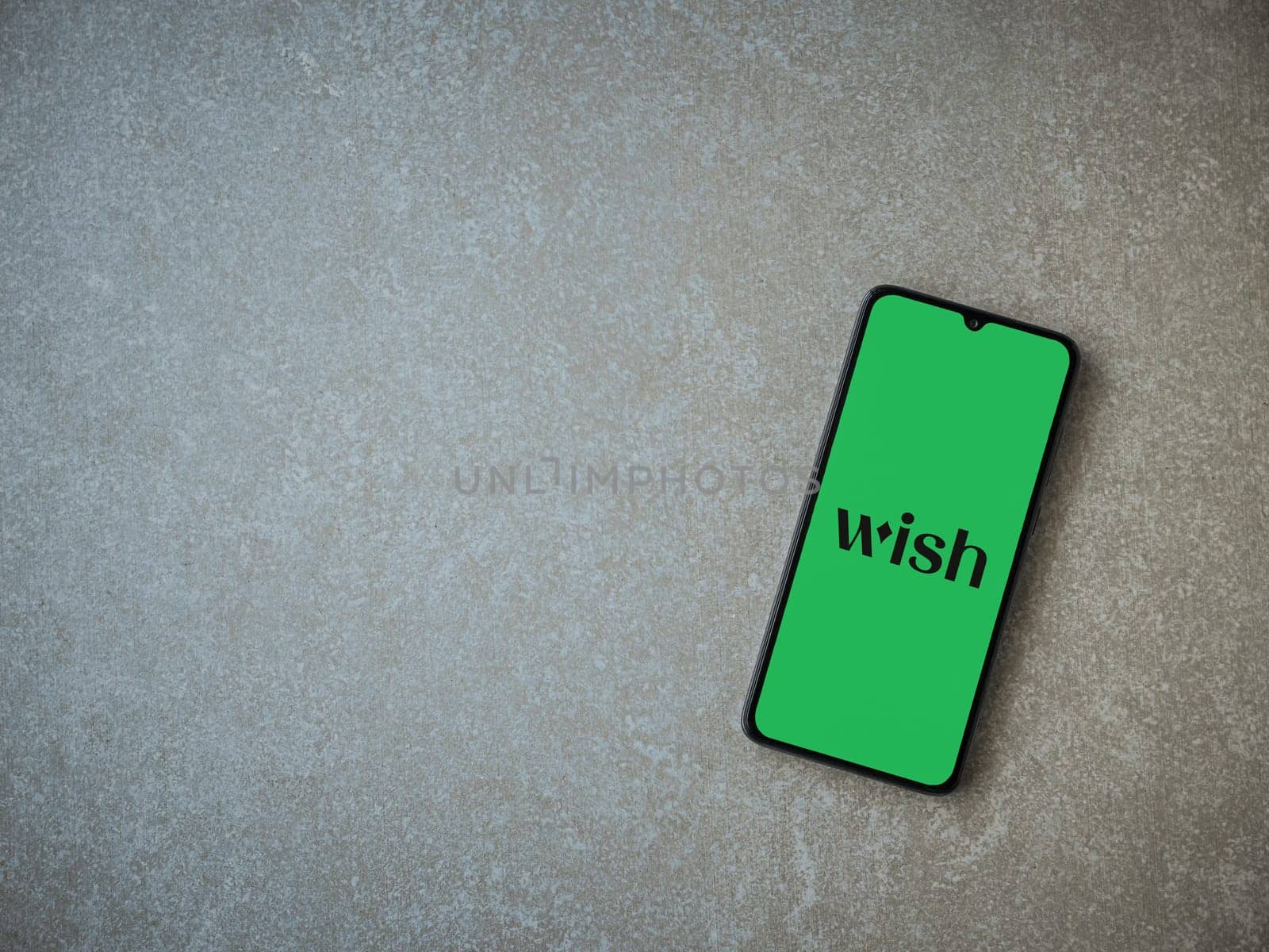Lod, Israel - July 16,2023: Wish app launch screen on smartphone on ceramic stone background. Top view flat lay with copy space.