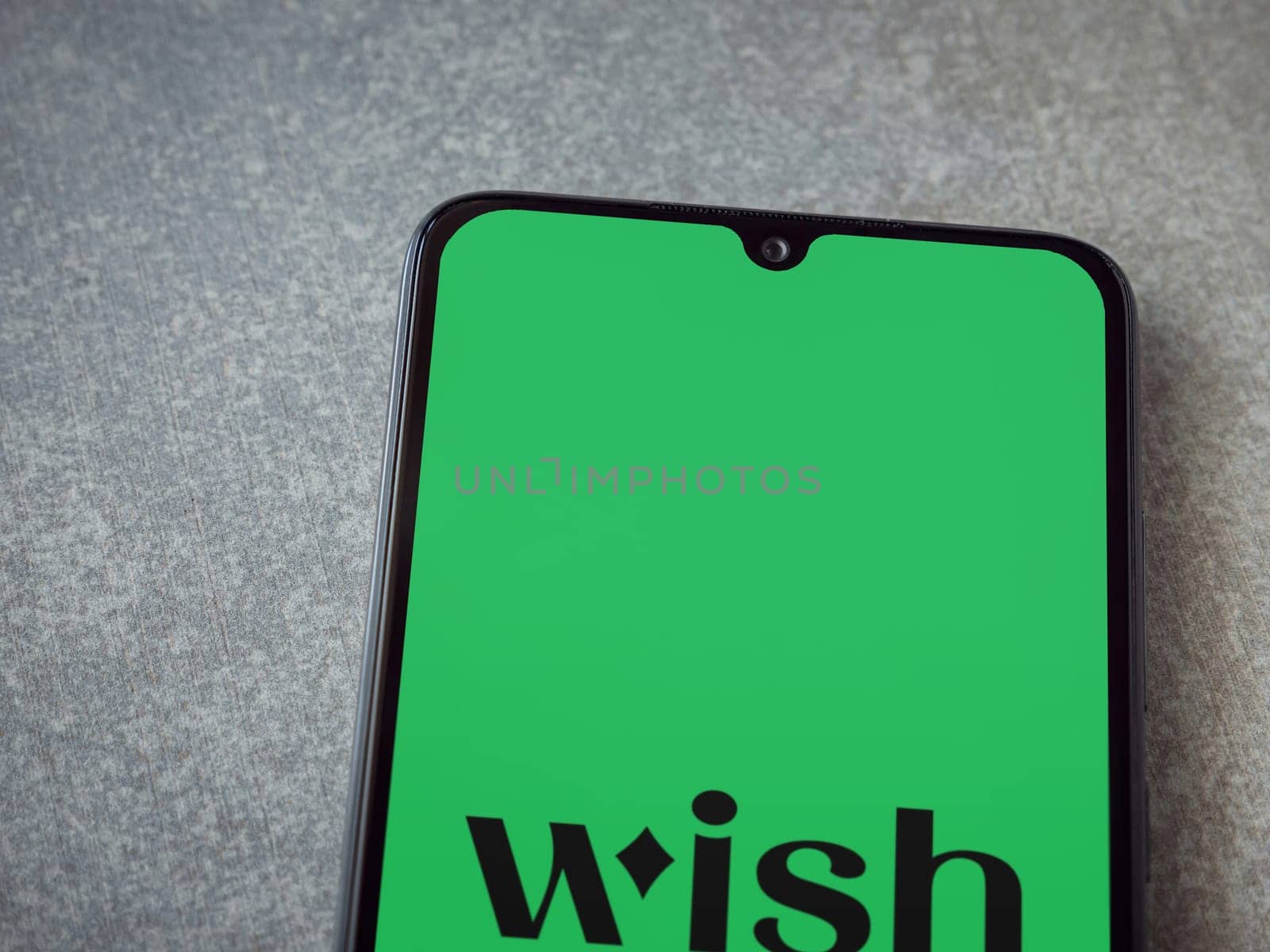 Lod, Israel - July 16,2023: Wish app launch screen on smartphone on ceramic stone background. Top view flat lay with copy space.