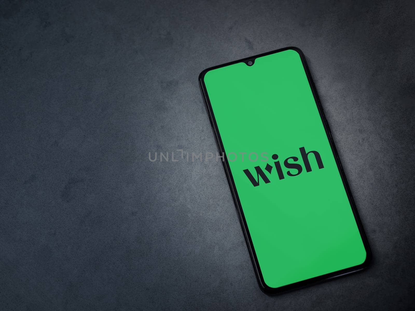 Lod, Israel - July 16,2023: Wish app launch screen on smartphone on dark marble stone background. Top view flat lay with copy space.