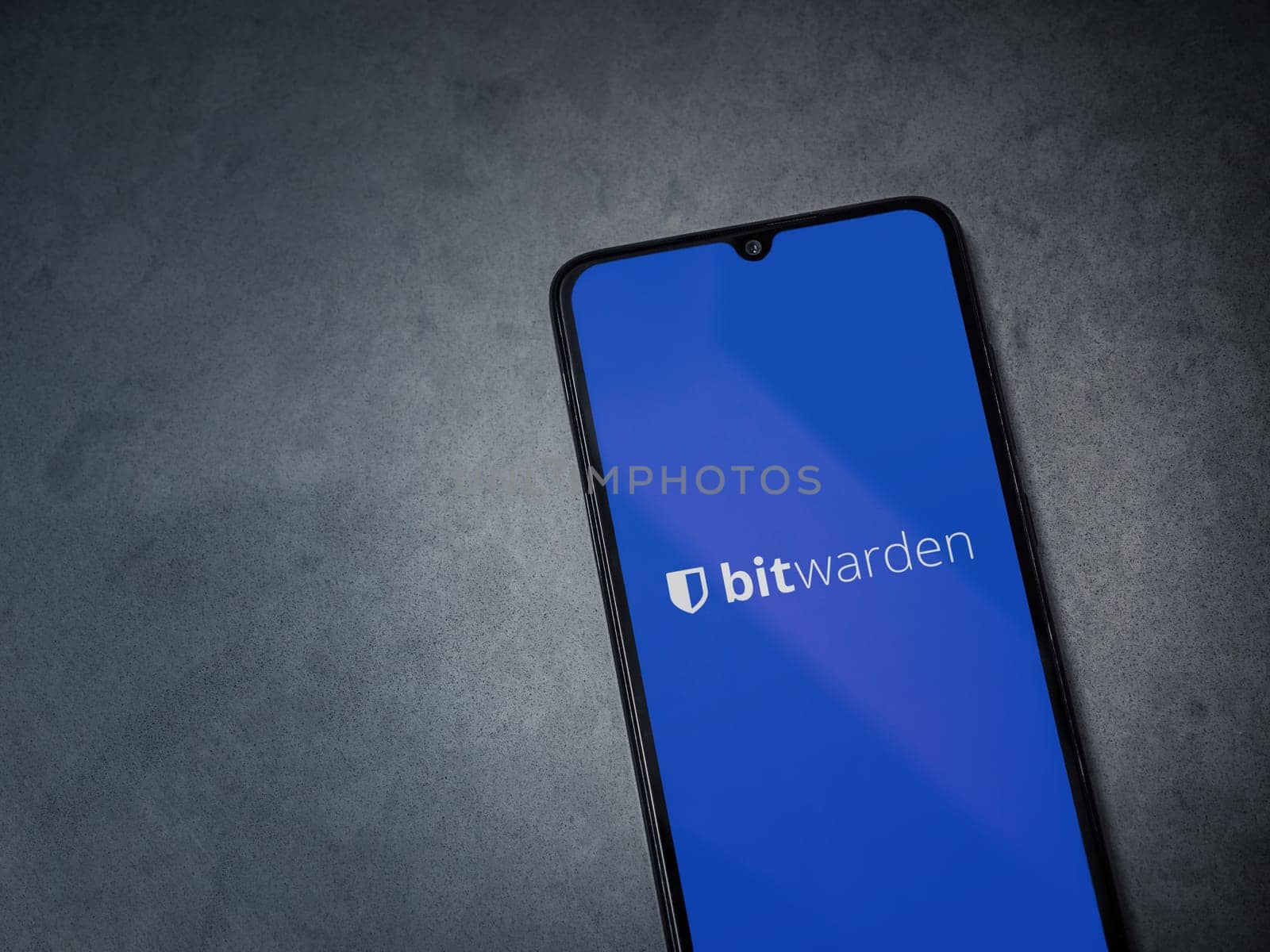 Lod, Israel - July 16,2023: Bitwarden Password Manager app launch screen on smartphone on dark marble stone background. Top view flat lay with copy space.
