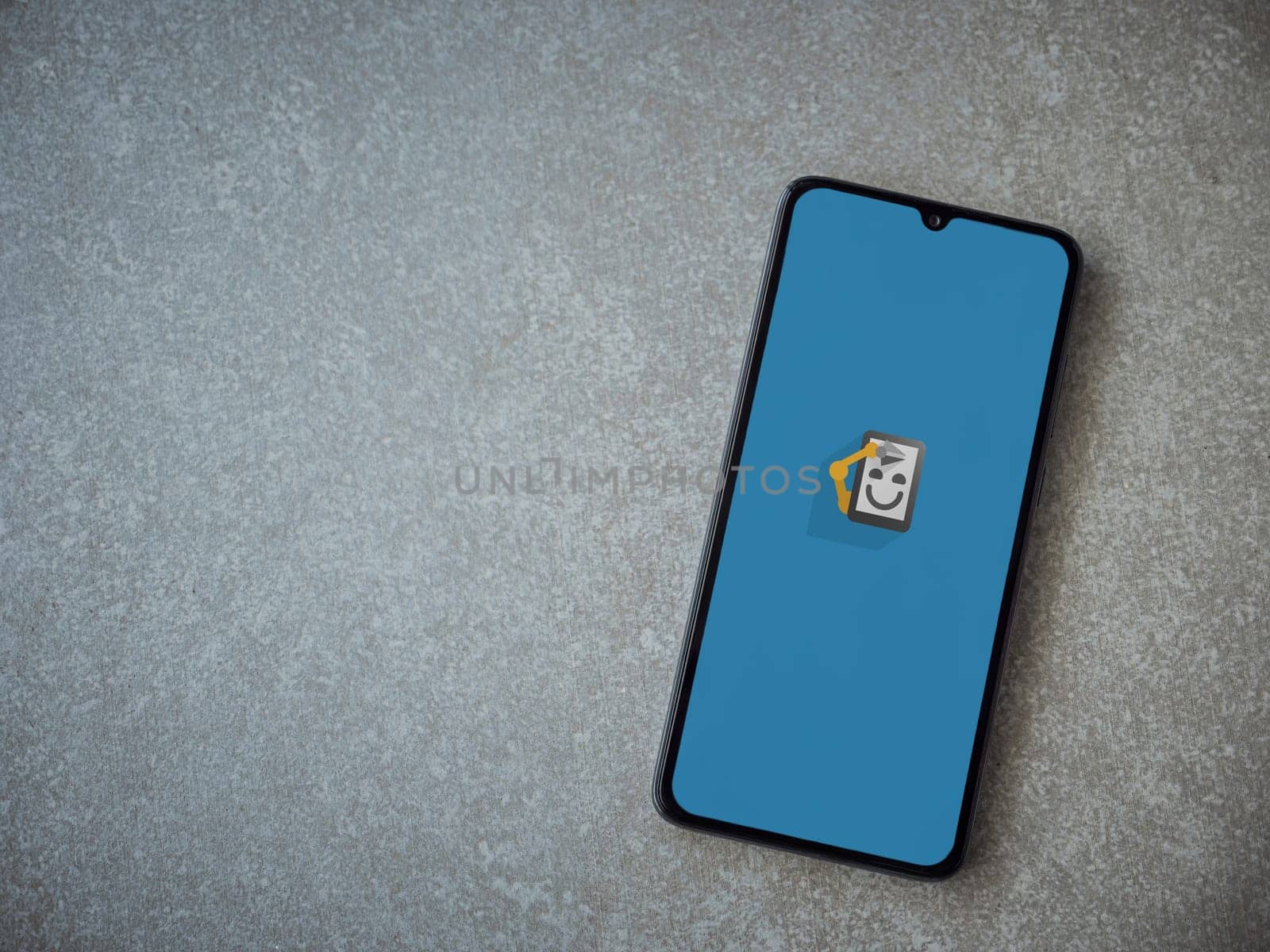 Lod, Israel - July 16,2023: Automate app launch screen on smartphone on ceramic stone background. Top view flat lay with copy space.