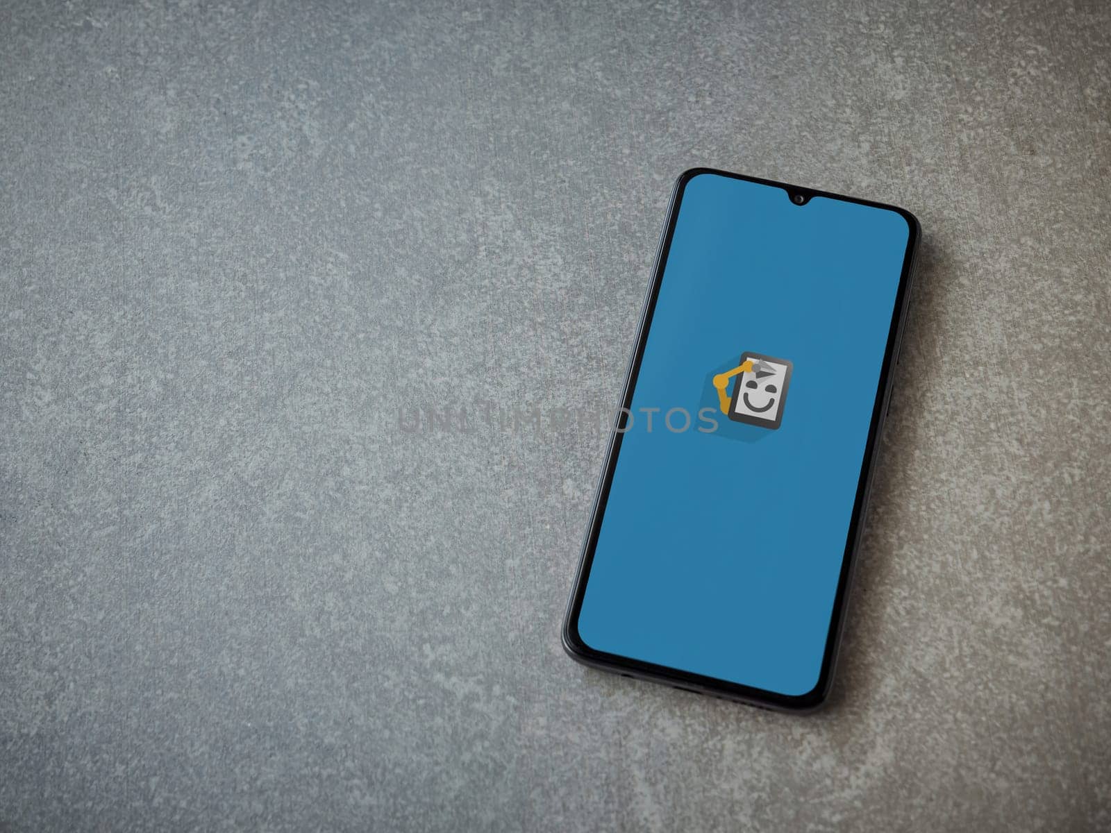 Lod, Israel - July 16,2023: Automate app launch screen on smartphone on ceramic stone background. Top view flat lay with copy space.