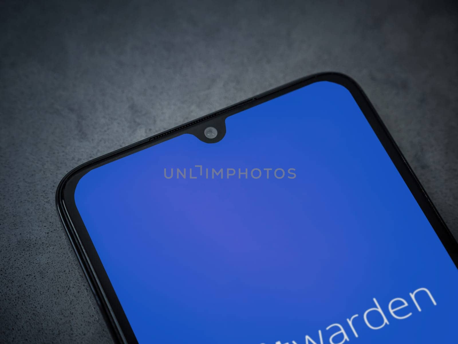 Lod, Israel - July 16,2023: Bitwarden Password Manager app launch screen on smartphone on dark marble stone background. Top view flat lay with copy space.
