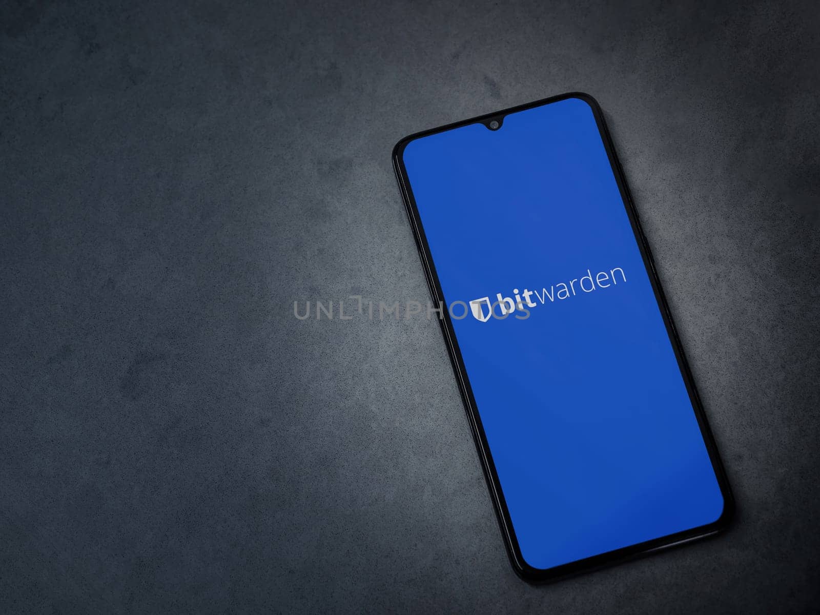 Lod, Israel - July 16,2023: Bitwarden Password Manager app launch screen on smartphone on dark marble stone background. Top view flat lay with copy space.
