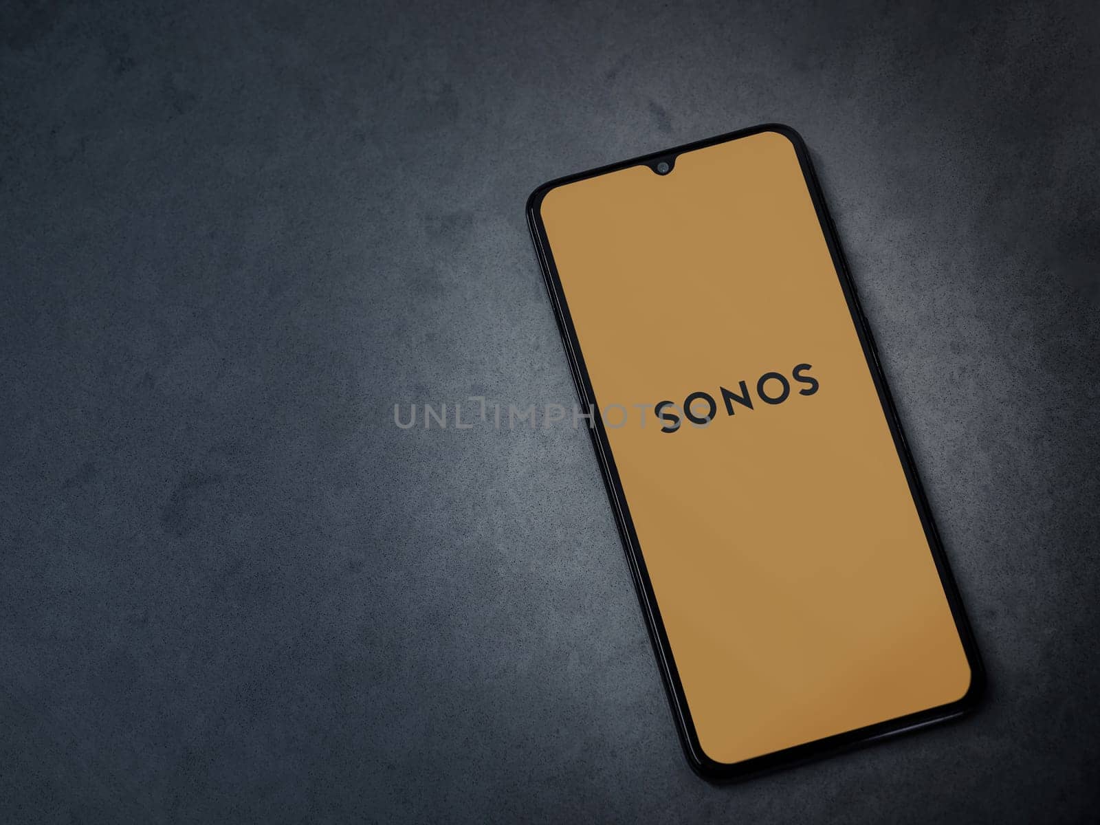 Lod, Israel - July 16,2023: Sonos app launch screen on smartphone on dark marble stone background. Top view flat lay with copy space.