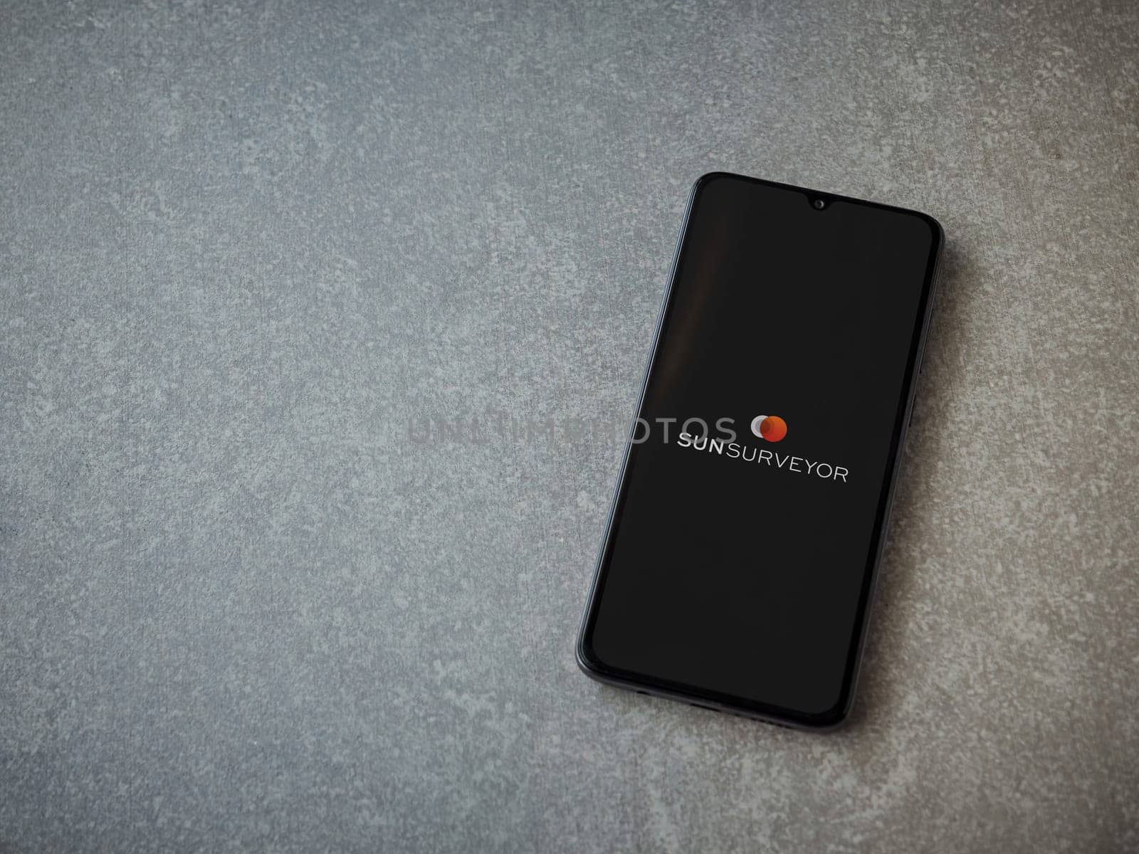 Lod, Israel - July 16,2023: Sun Surveyor app launch screen on smartphone on ceramic stone background. Top view flat lay with copy space.