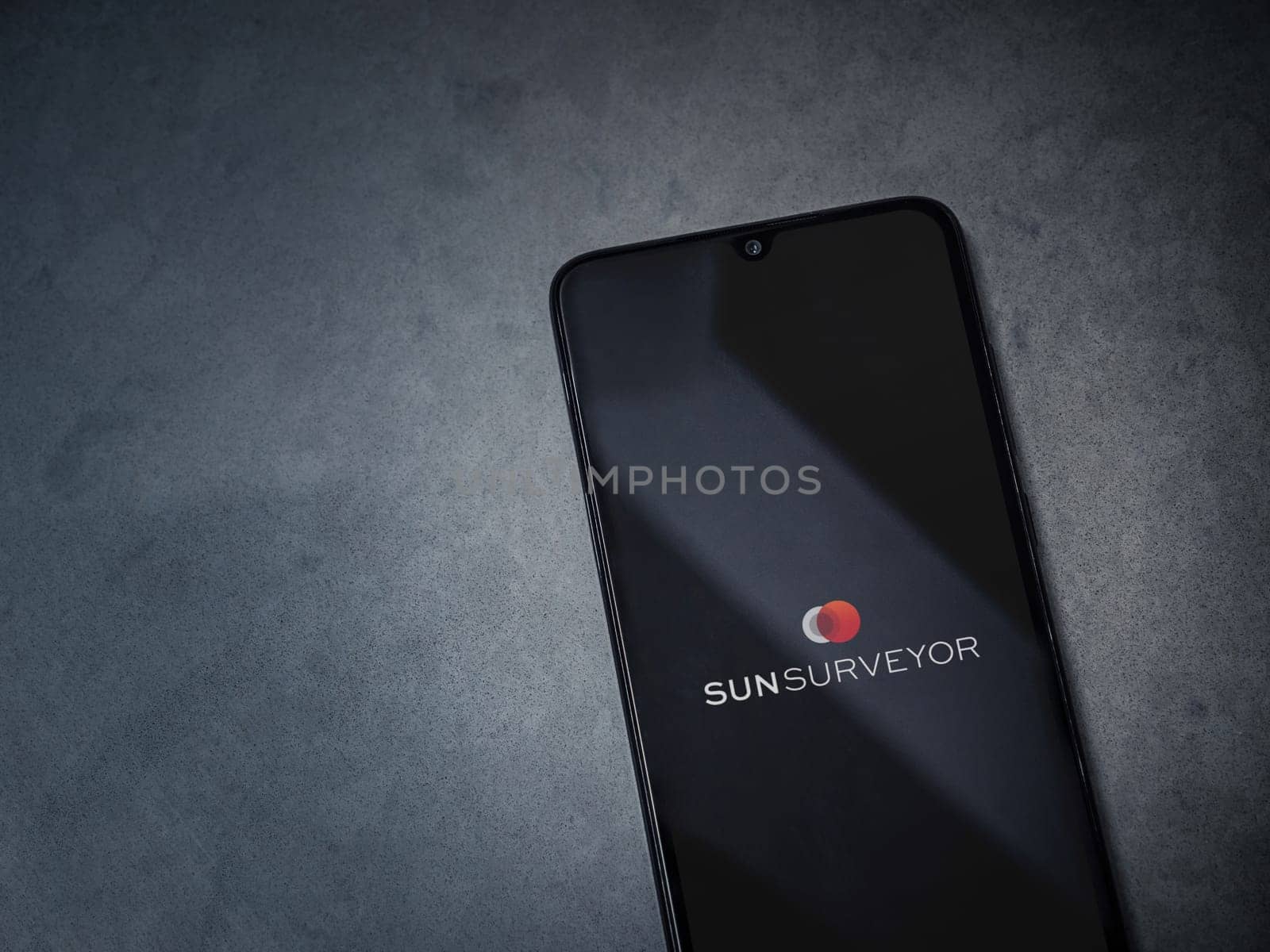 Lod, Israel - July 16,2023: Sun Surveyor app launch screen on smartphone on dark marble stone background. Top view flat lay with copy space.