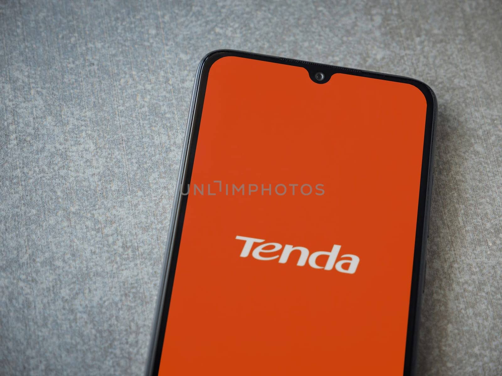 Lod, Israel - July 16,2023: Tenda Wifi app launch screen on smartphone on ceramic stone background. Top view flat lay with copy space.