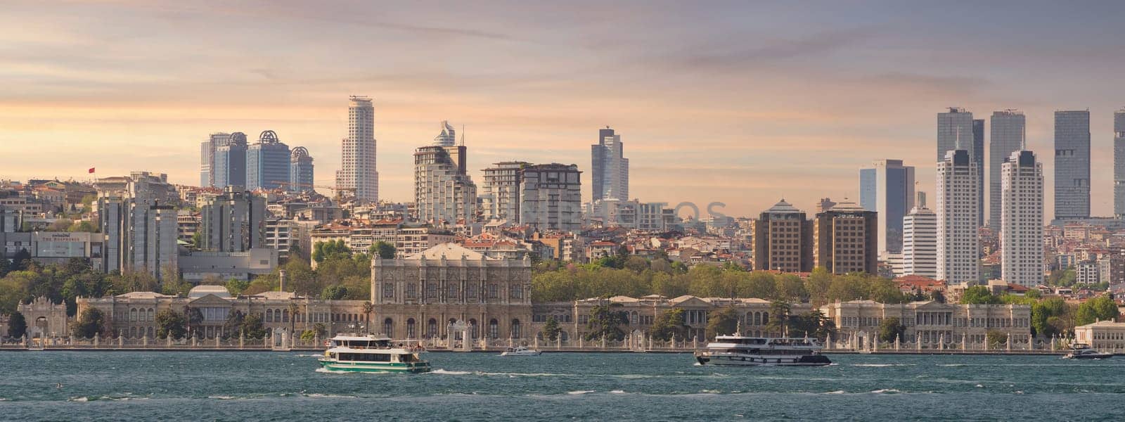 Stunning view of the city of Istanbul, Turkey from across the Bosphorus strait. The image captures the beauty of the city's skyline, with its iconic buildings including Dolmabahce Palace before sunset