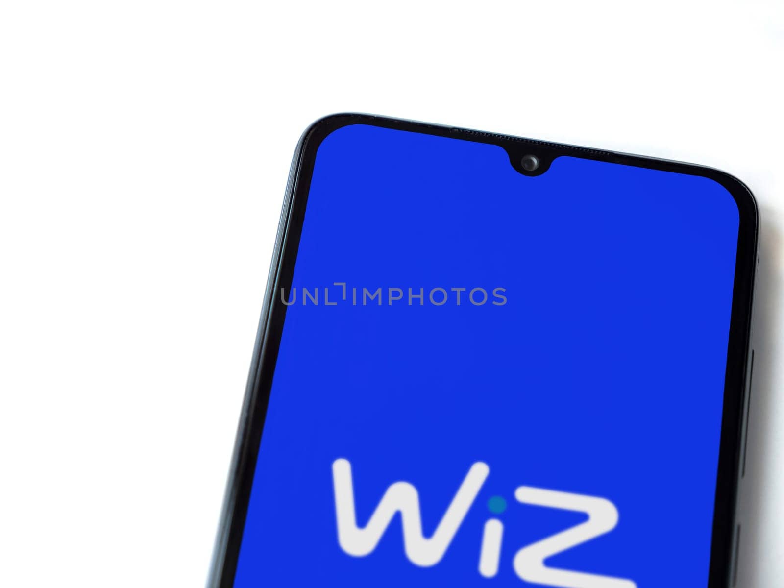 Lod, Israel - July 16,2023: WIZ app launch screen on smartphone on white background. Top view flat lay with copy space.