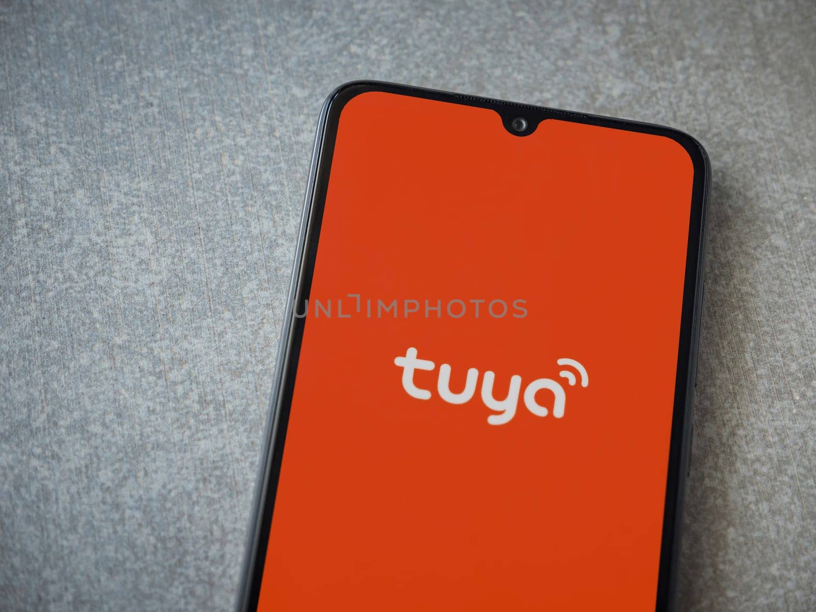 Lod, Israel - July 16,2023: Tuya Smart app launch screen on smartphone on ceramic stone background. Top view flat lay with copy space.