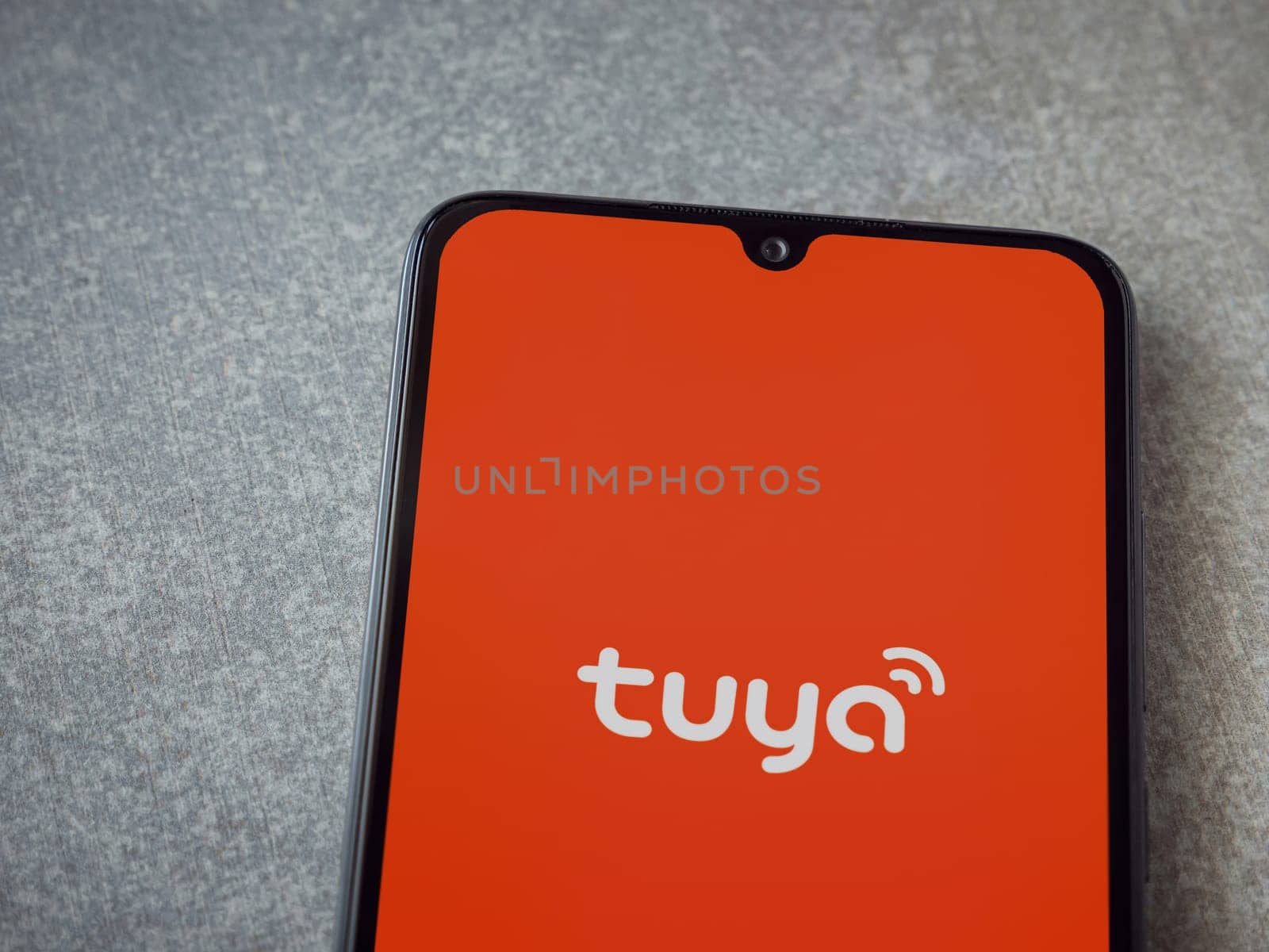 Lod, Israel - July 16,2023: Tuya Smart app launch screen on smartphone on ceramic stone background. Top view flat lay with copy space.