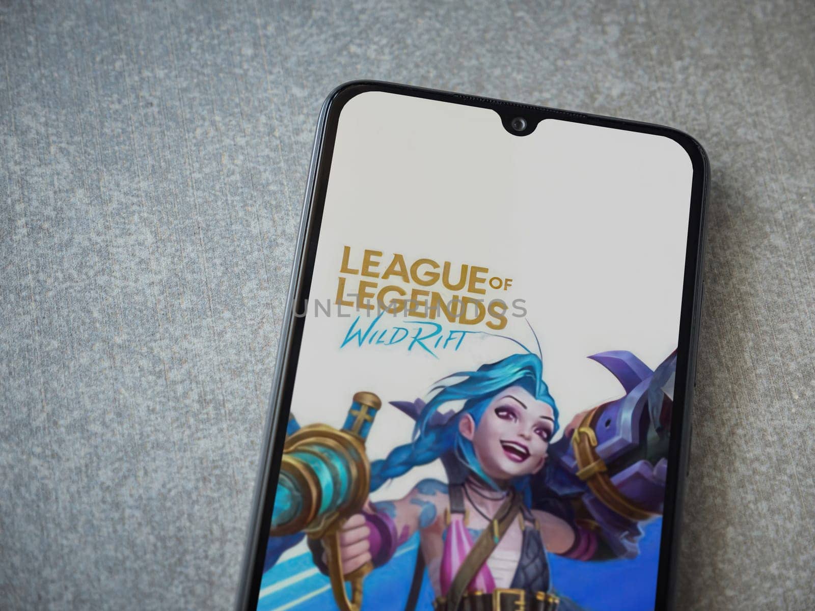 Lod, Israel - July 16,2023: League of Legends - Wild Rift app launch screen on smartphone on ceramic stone background. Top view flat lay with copy space.