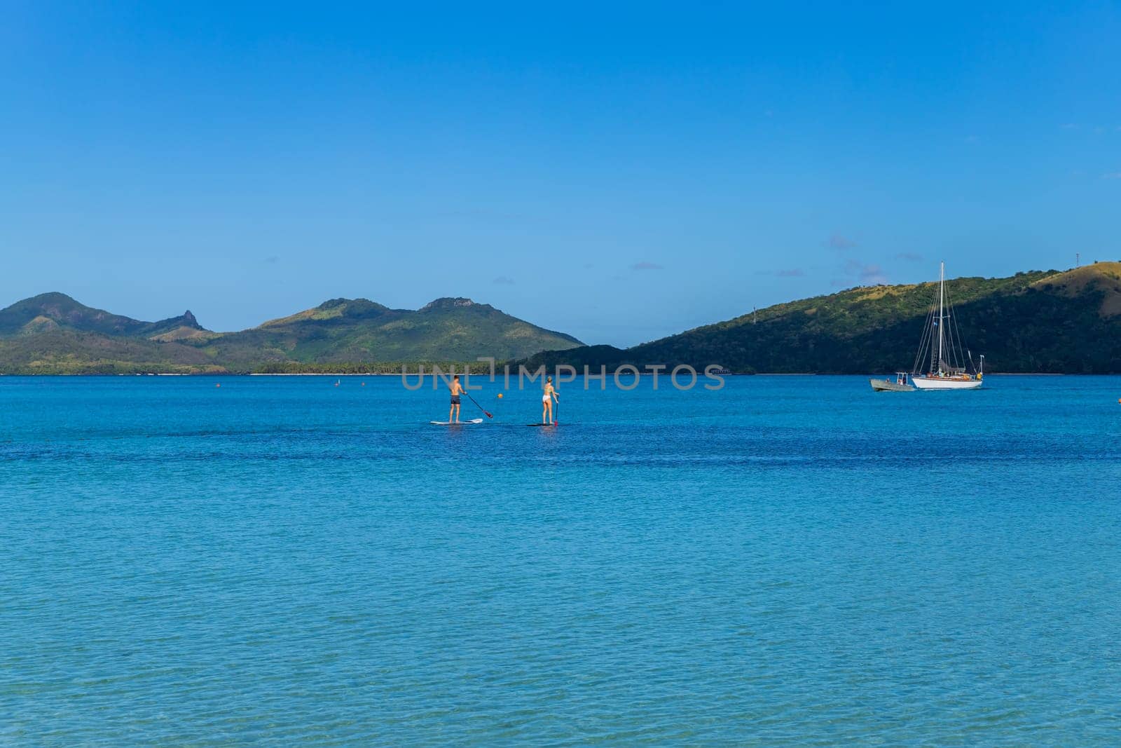 Nacula, Fiji: 26 May 2023: happy couple enjoying stand up paddling during summer vacation. Nacula Island, Fiji