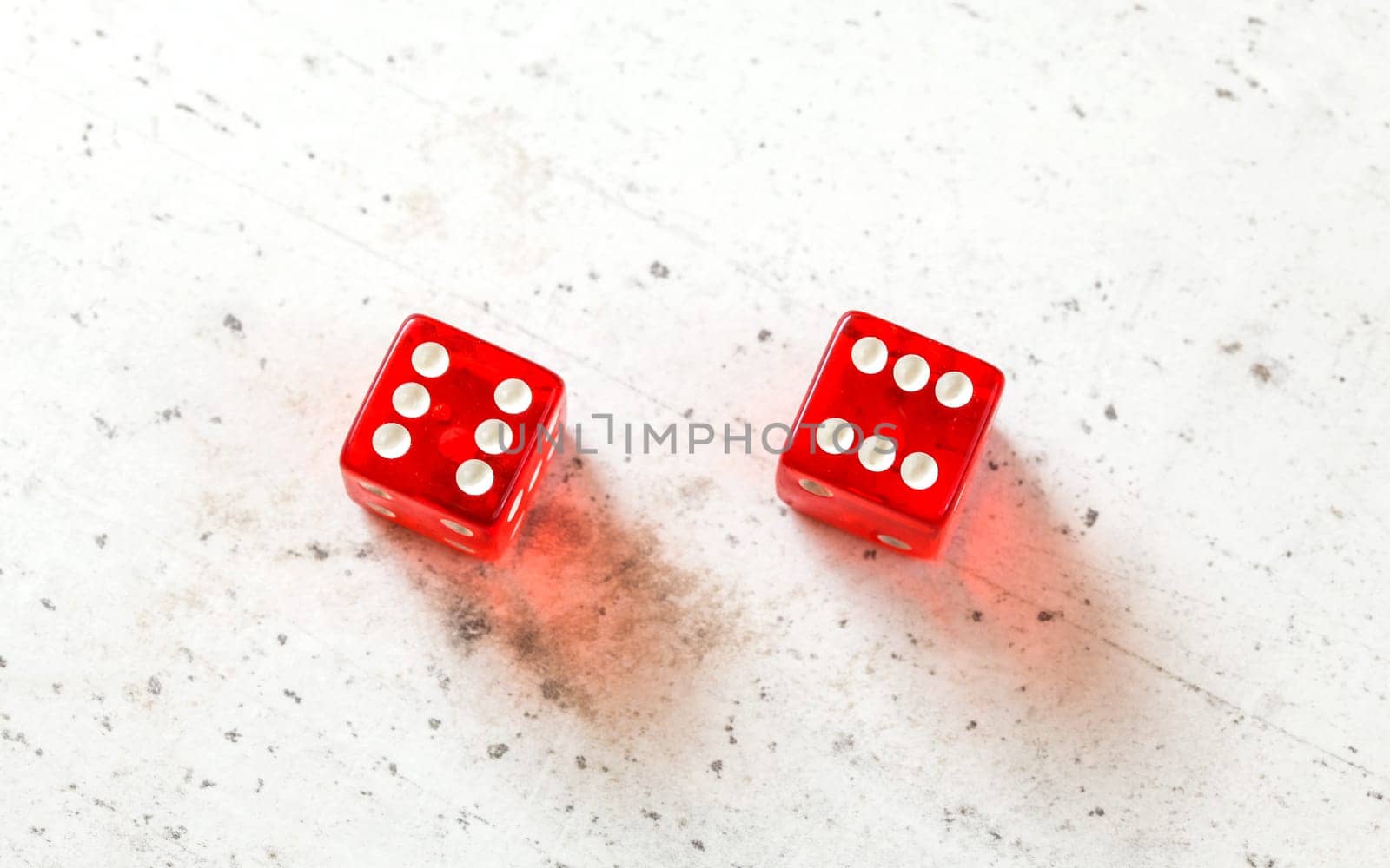 Two red craps dices showing Boxcars or Midnight (double number six) overhead shot on white board