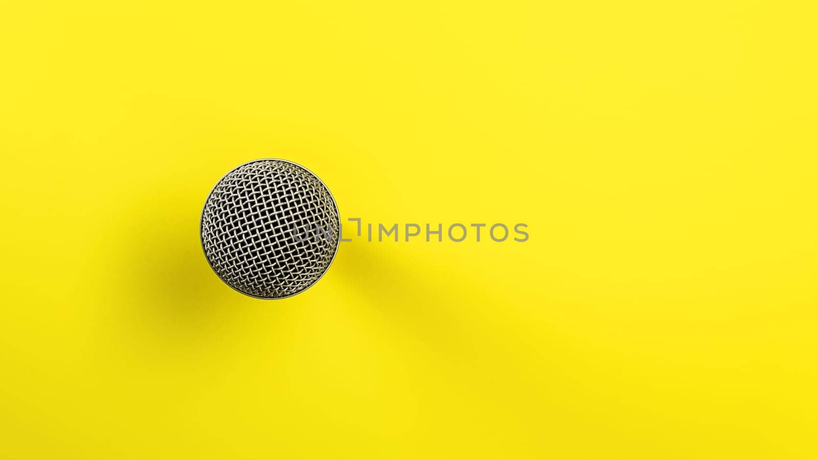 Microphone on yellow board, direct top down view, only ball with grid visible making so it looks abstract.
