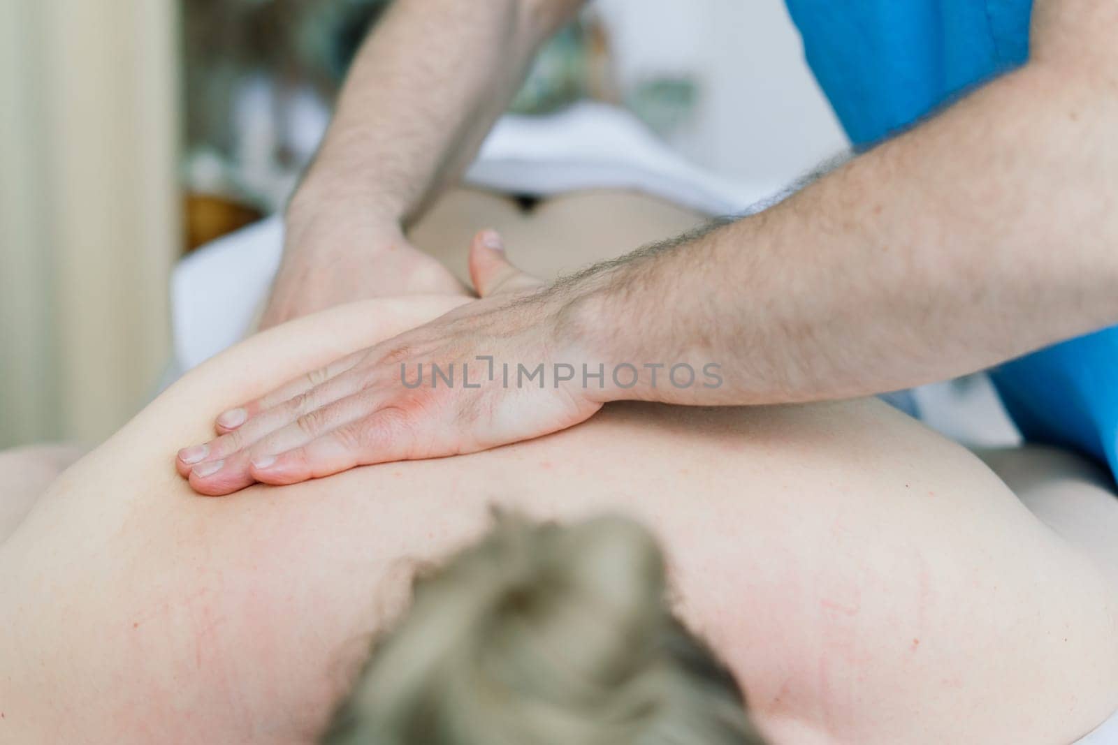Young fat woman getting massage treatment in a day spa cabinet.