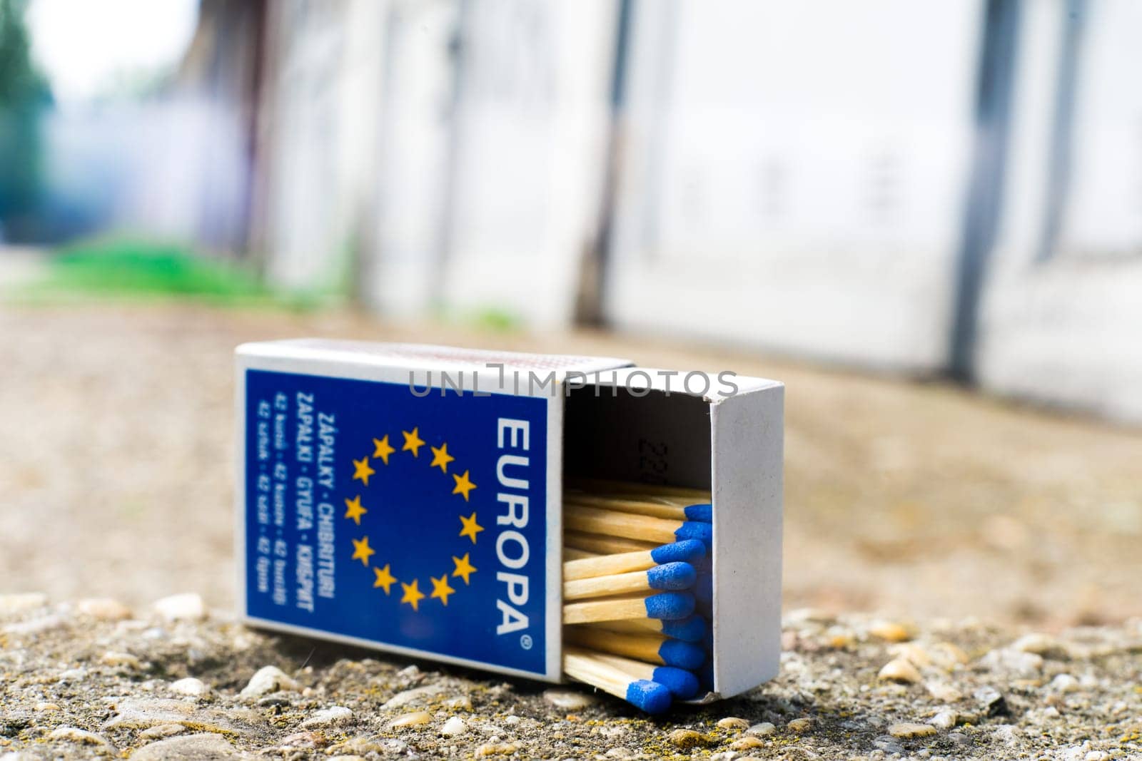 A match, a hand with matches against the background of old garages in city.