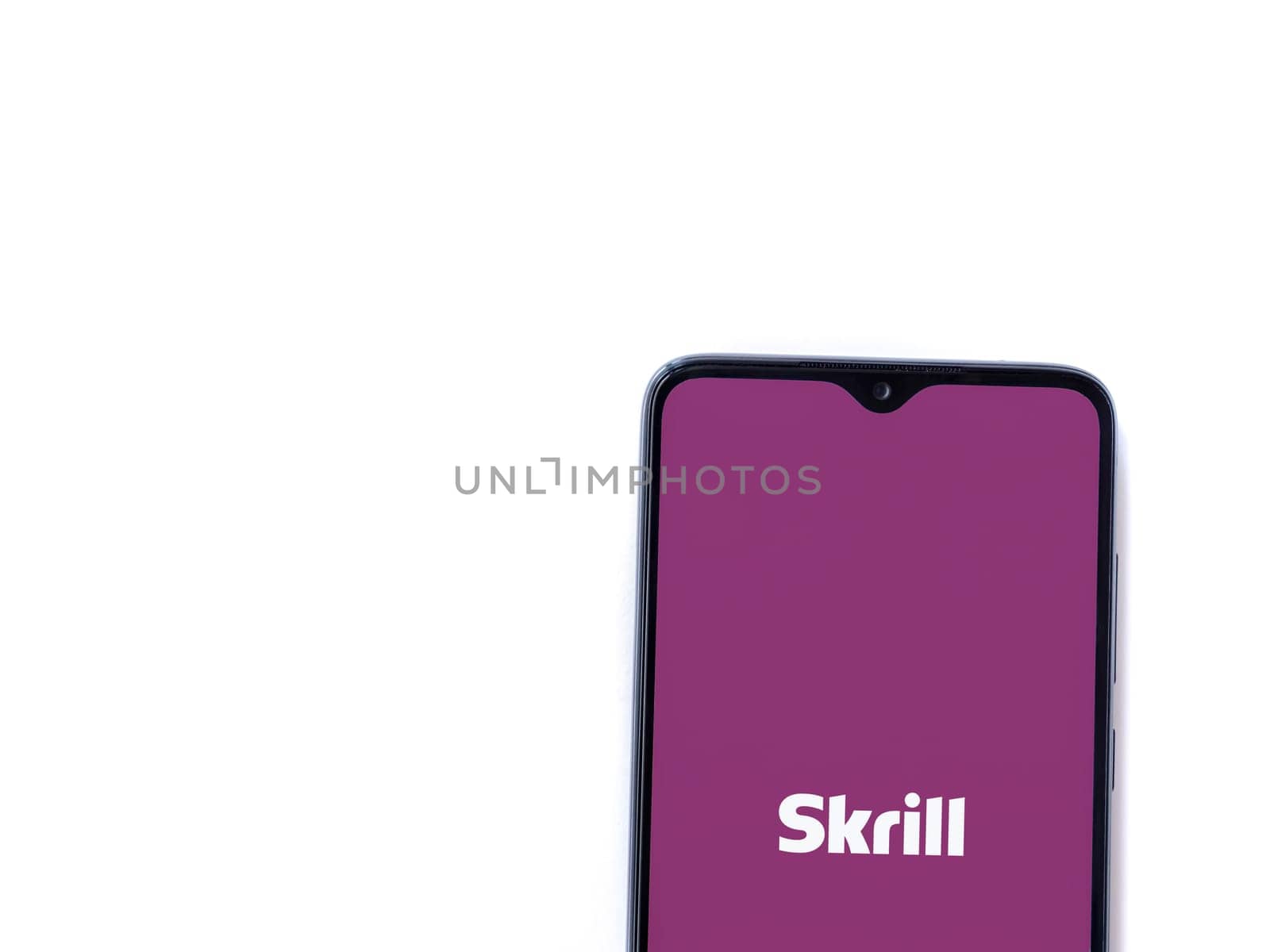 Lod, Israel - July 16,2023: Skrill app launch screen on smartphone on white background. Top view flat lay with copy space.
