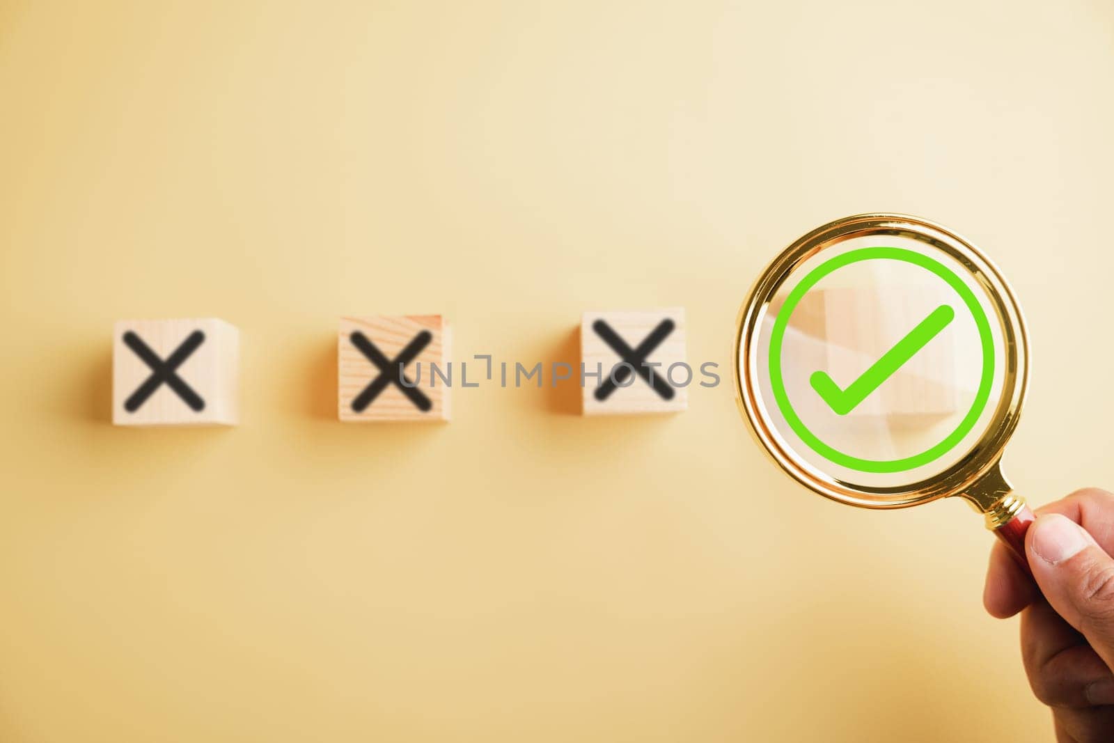 Hand holding a magnifying glass focuses on the right choice concept, with a checkmark or tick symbol next to wrong cross icons. Emphasizing the importance of making the correct decision.