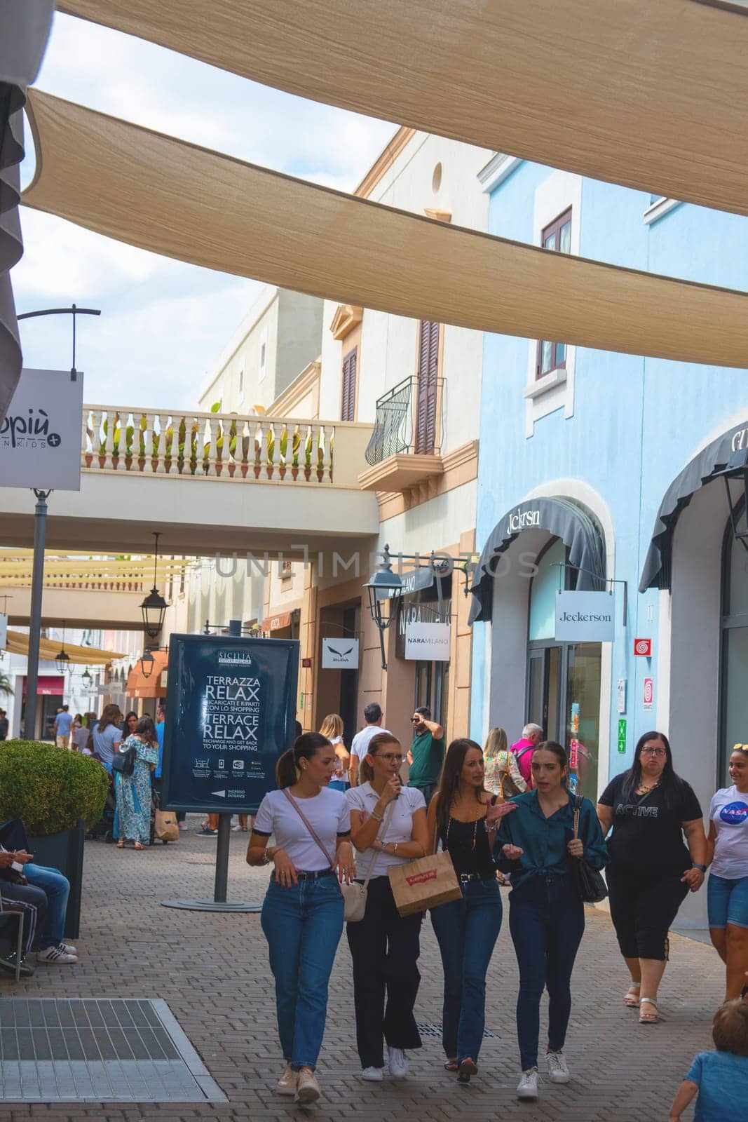 Sicily, Italy, Agira - 30 Sep 2023. Sicilia Outlet Village shopping centre is a popular visitor magnet. Passage with people where shopping at Outlet Village.
