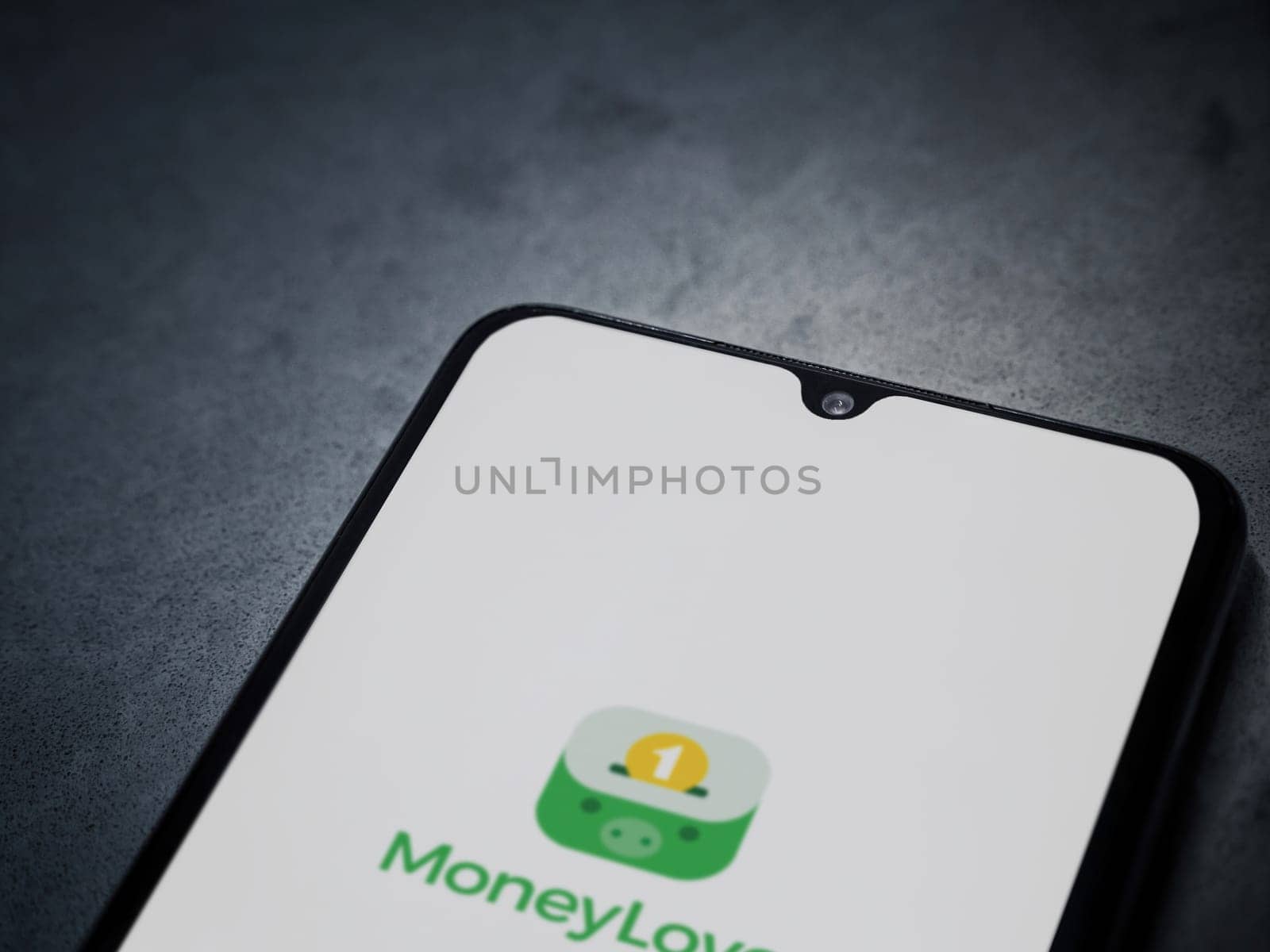 Lod, Israel - July 16,2023: Money Lover app launch screen on smartphone on dark marble stone background. Top view flat lay with copy space.