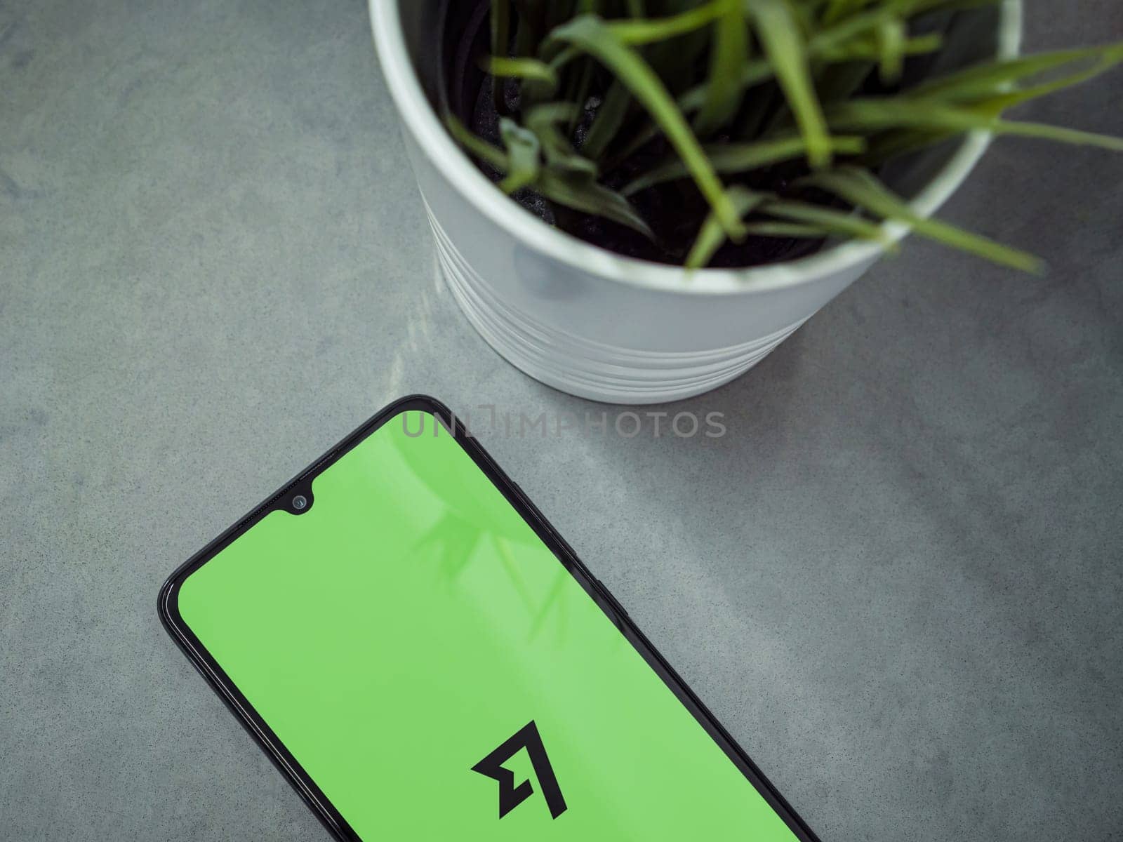 Lod, Israel - July 16,2023: Modern workspace with smartphone with Wise app launch screen on marble background. Close up top view flat lay.
