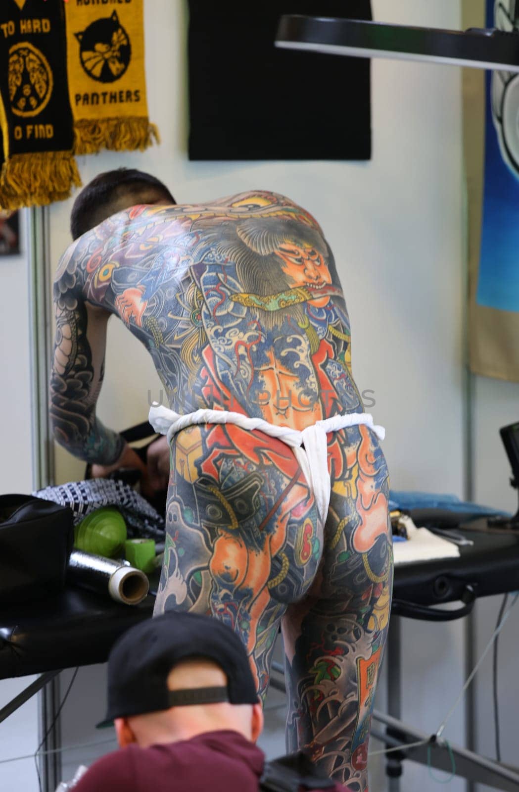 Krakow, Poland -  June 11, 2022: Unidentified  participant at 15th Tattoofest Convention in Cracow. One of the most prestigious tattoo festivals. Tattoo artist at work.