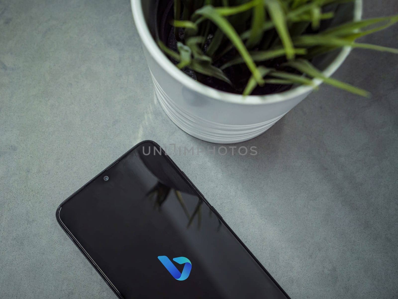 Lod, Israel - July 16,2023: Modern workspace with smartphone with Bing Browser app launch screen on marble background. Close up top view flat lay.