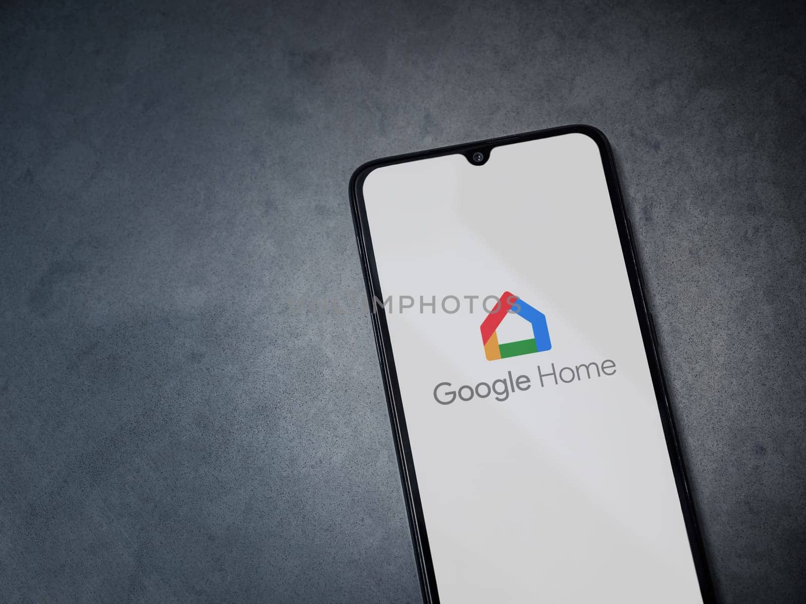 Lod, Israel - July 16,2023: Google Home app launch screen on smartphone on dark marble stone background. Top view flat lay with copy space.