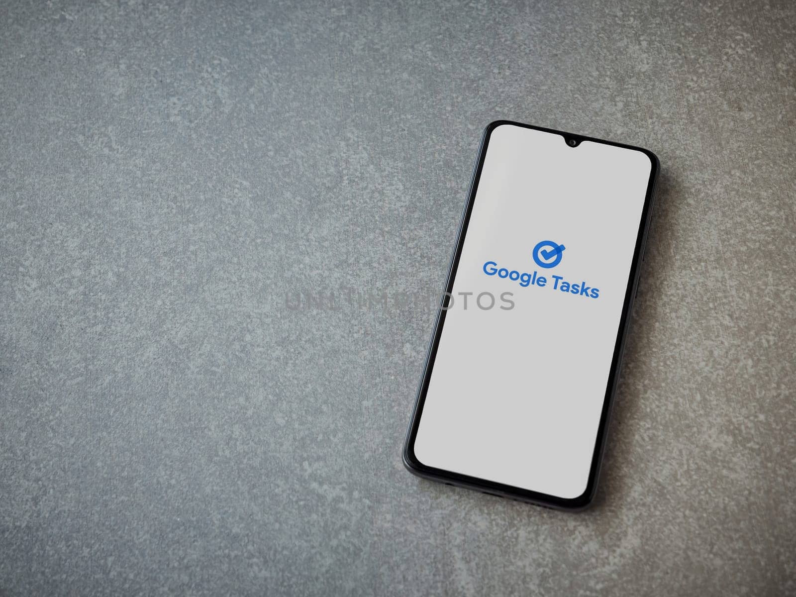 Lod, Israel - July 16,2023: Google Task app launch screen on smartphone on ceramic stone background. Top view flat lay with copy space.
