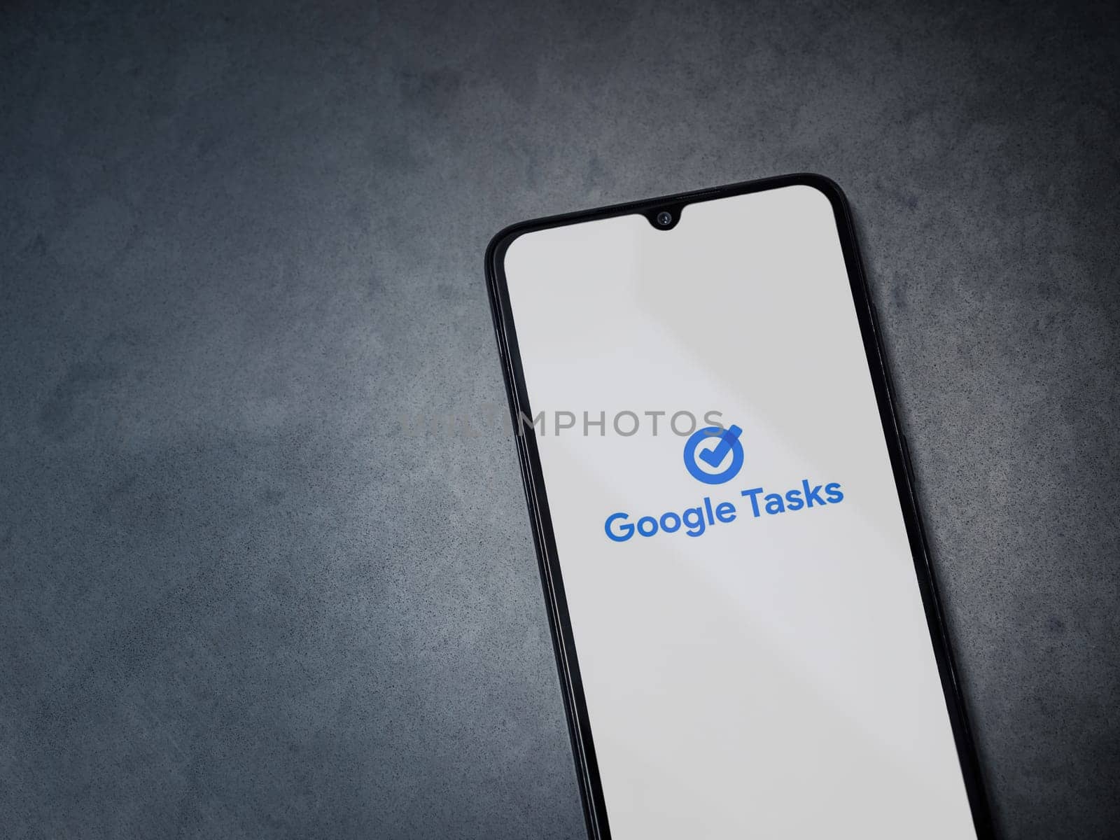 Lod, Israel - July 16,2023: Google Task app launch screen on smartphone on dark marble stone background. Top view flat lay with copy space.