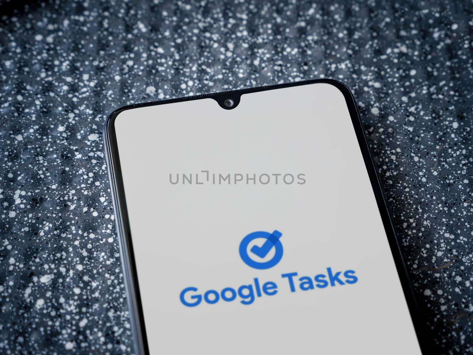 Lod, Israel - July 16,2023: Google Task app launch screen on smartphone on metallic background. Close up top view flat lay.