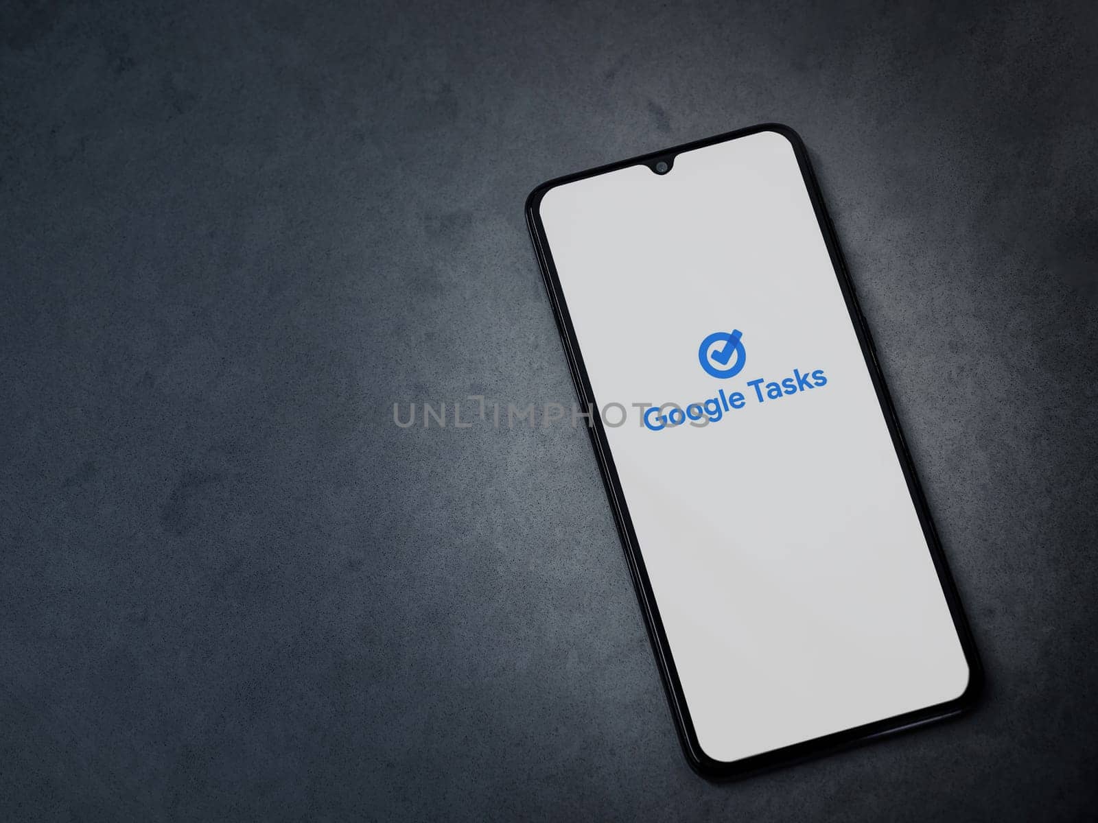 Lod, Israel - July 16,2023: Google Task app launch screen on smartphone on dark marble stone background. Top view flat lay with copy space.