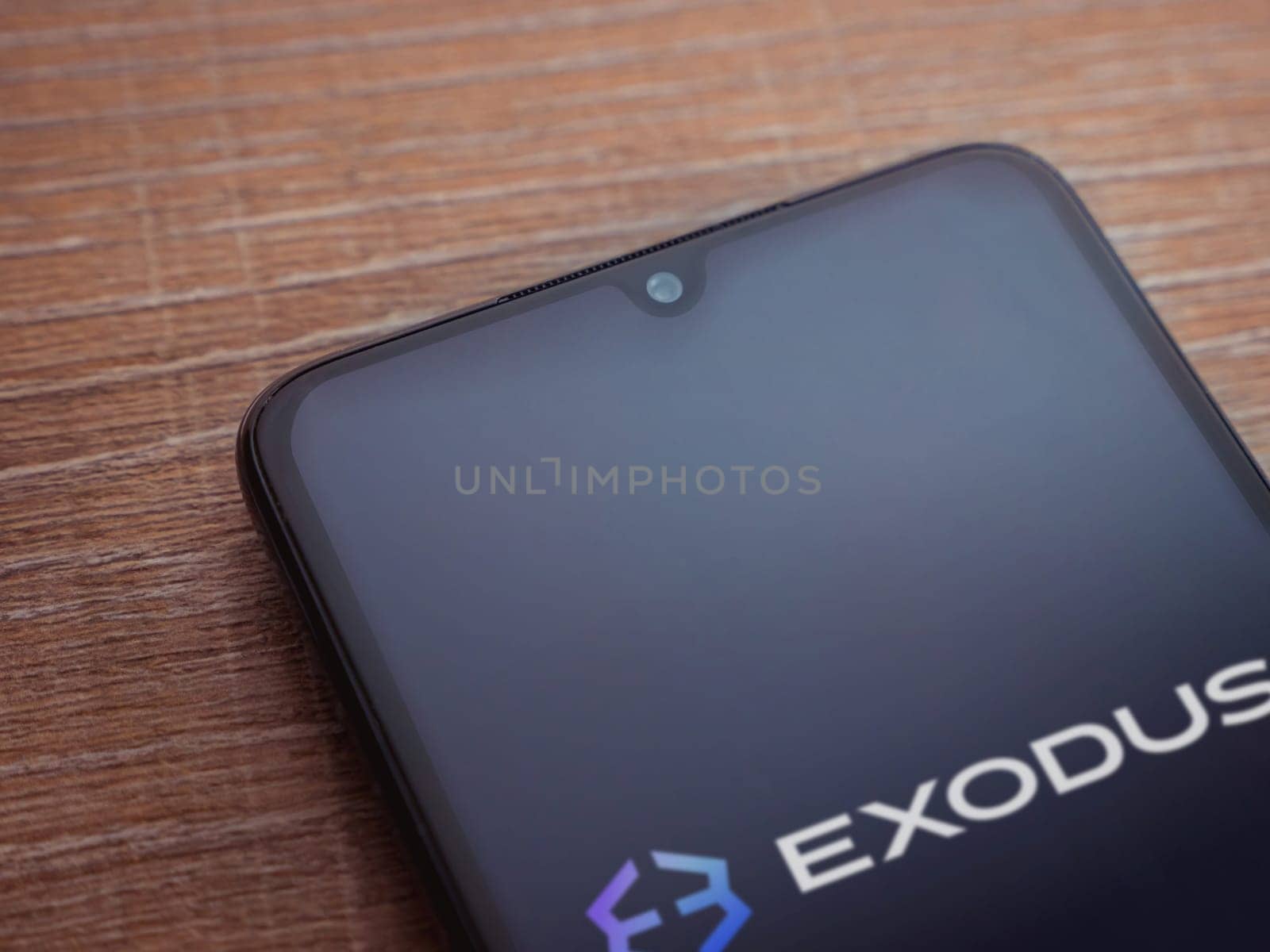 Lod, Israel - July 16,2023: Exodus app launch screen on smartphone on wooden background. Top view flat lay with copy space.