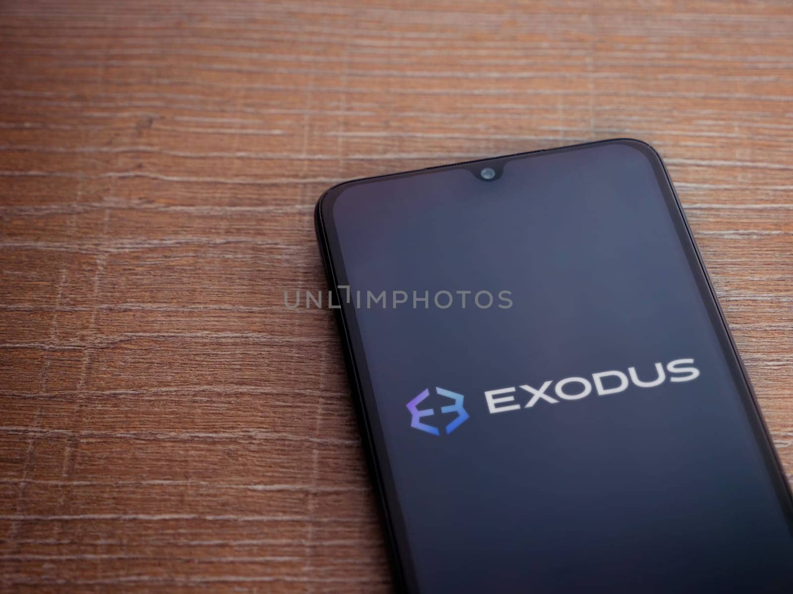 Lod, Israel - July 16,2023: Exodus app launch screen on smartphone on wooden background. Top view flat lay with copy space.