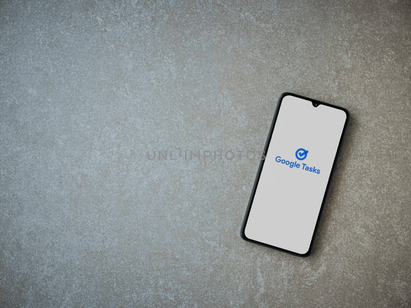 Lod, Israel - July 16,2023: Google Task app launch screen on smartphone on ceramic stone background. Top view flat lay with copy space.
