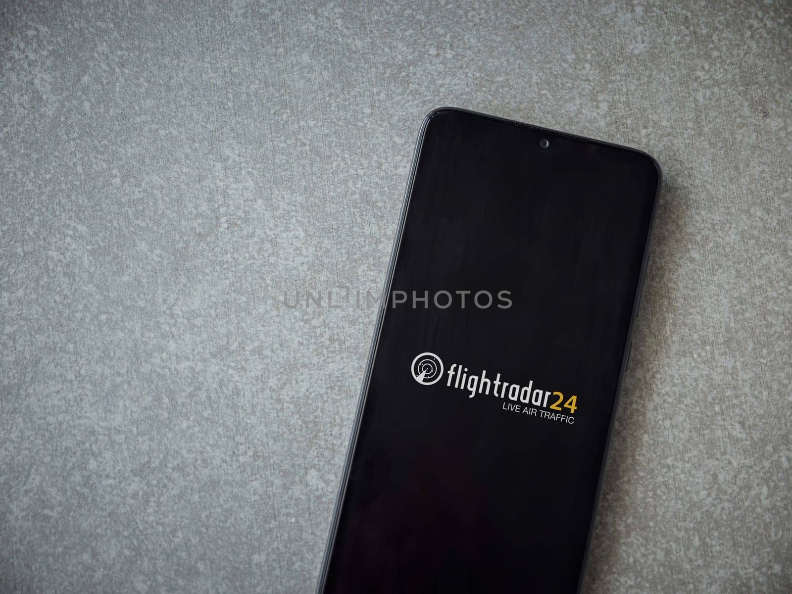 Lod, Israel - July 16,2023: Flightradar24 Flight Tracker app launch screen on smartphone on ceramic stone background. Top view flat lay with copy space.