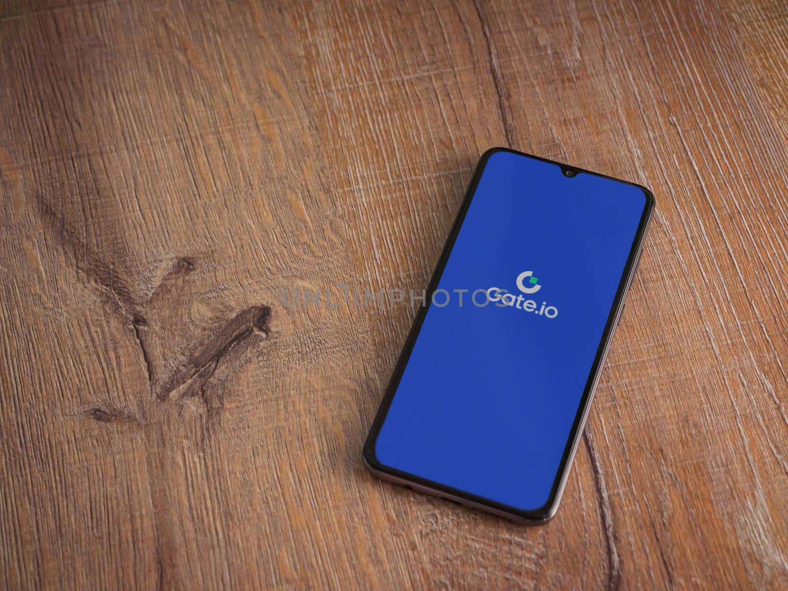 Lod, Israel - July 16,2023: Gate.io app launch screen on smartphone on wooden background. Top view flat lay with copy space.