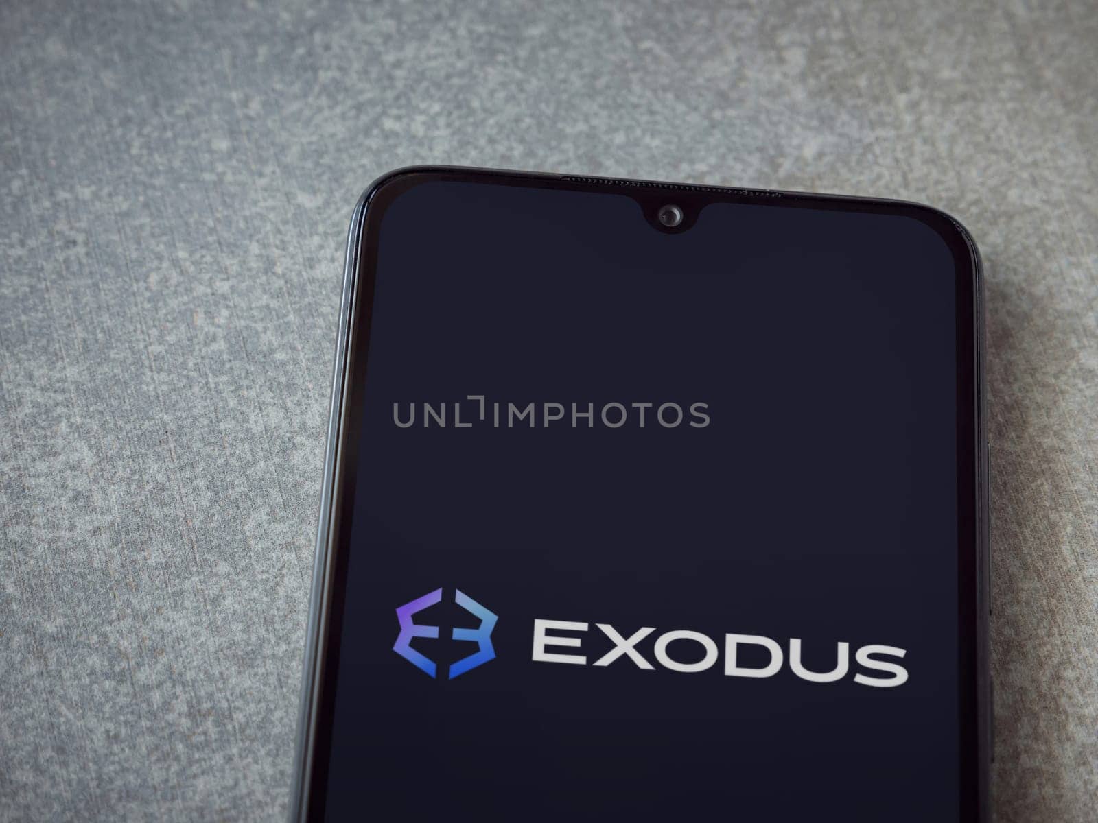 Lod, Israel - July 16,2023: Exodus app launch screen on smartphone on ceramic stone background. Top view flat lay with copy space.
