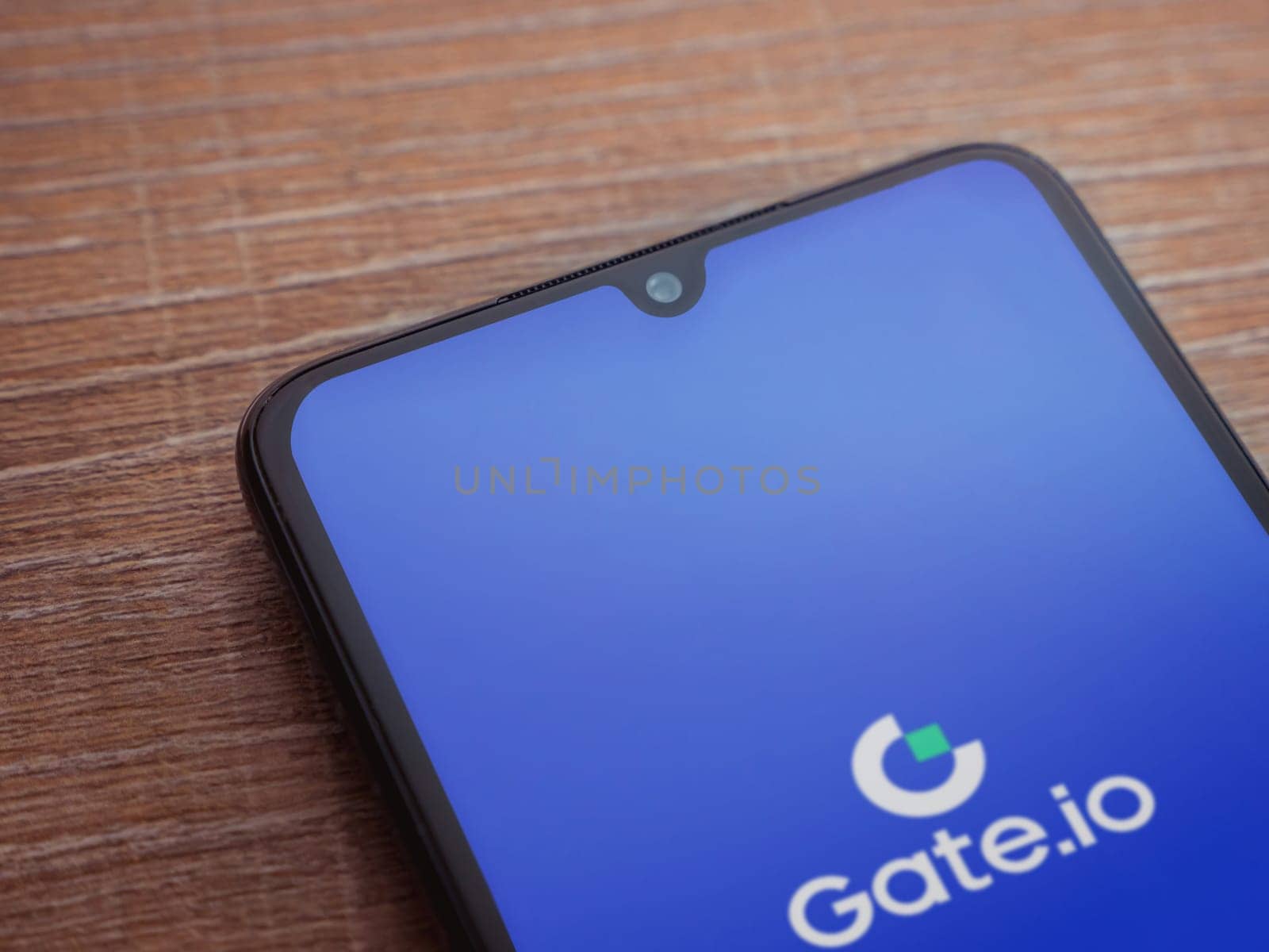 Lod, Israel - July 16,2023: Gate.io app launch screen on smartphone on wooden background. Top view flat lay with copy space.