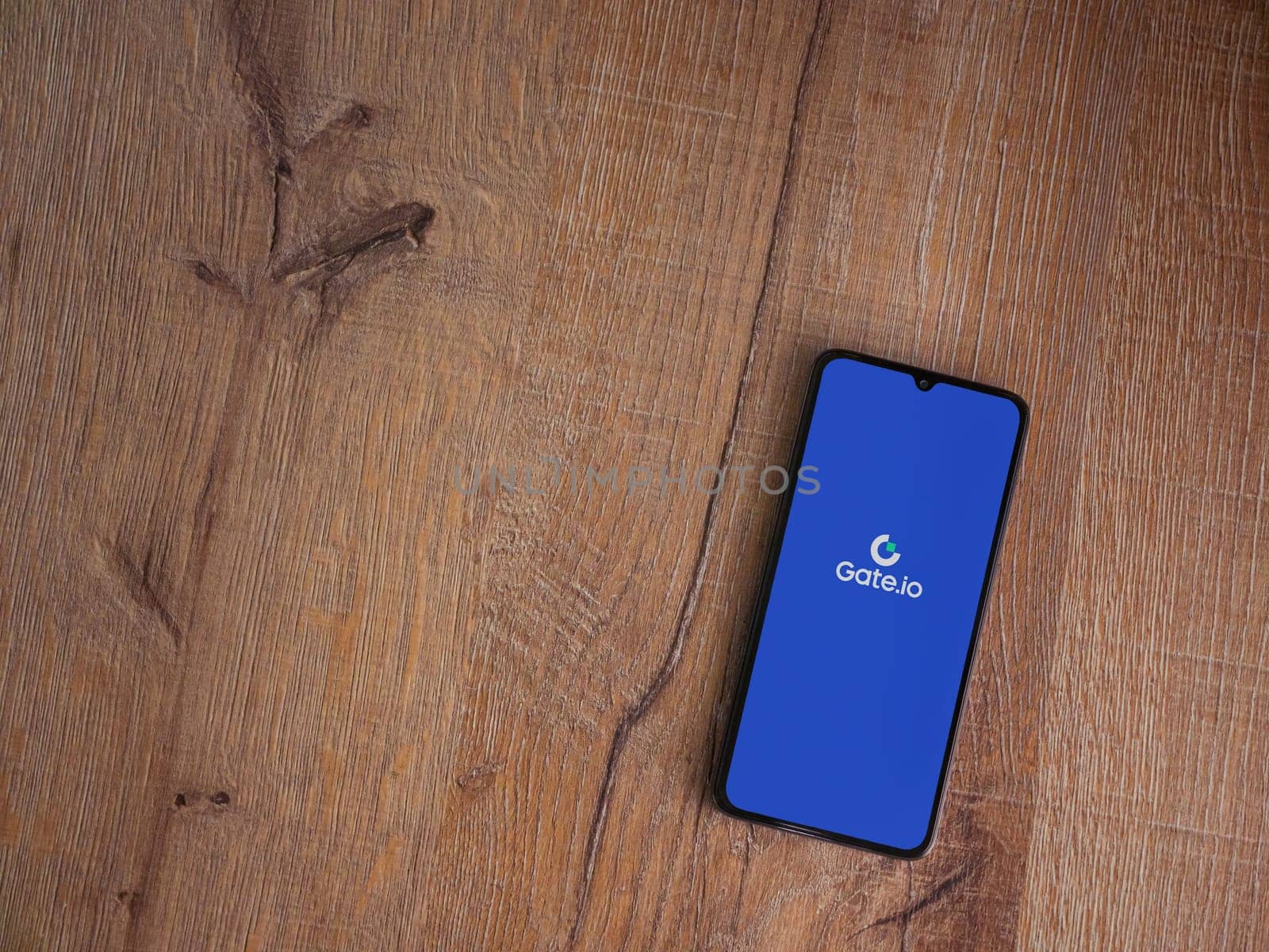 Lod, Israel - July 16,2023: Gate.io app launch screen on smartphone on wooden background. Top view flat lay with copy space.