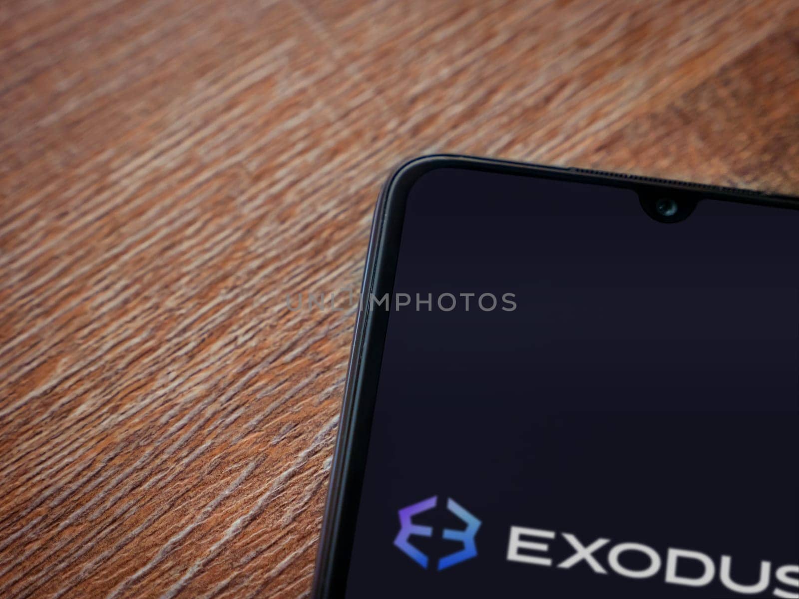 Lod, Israel - July 16,2023: Exodus app launch screen on smartphone on wooden background. Top view flat lay with copy space.