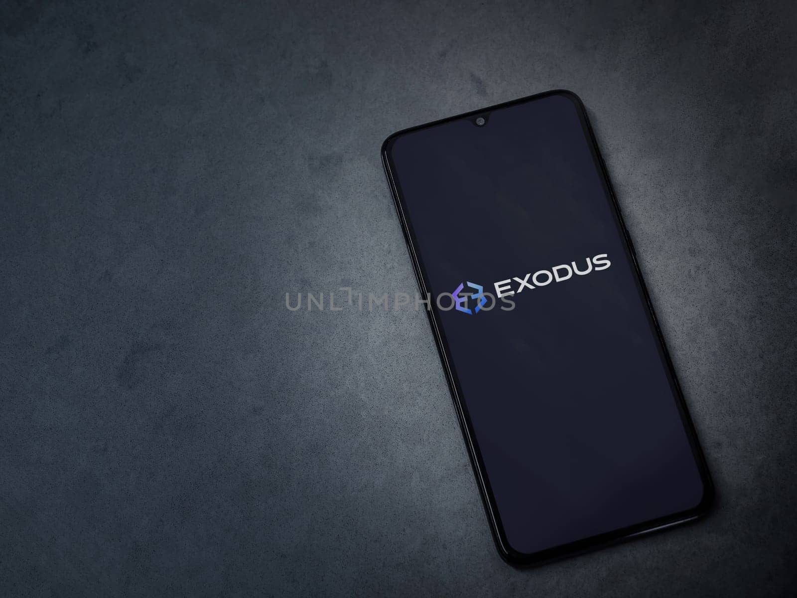 Lod, Israel - July 16,2023: Exodus app launch screen on smartphone on dark marble stone background. Top view flat lay with copy space.