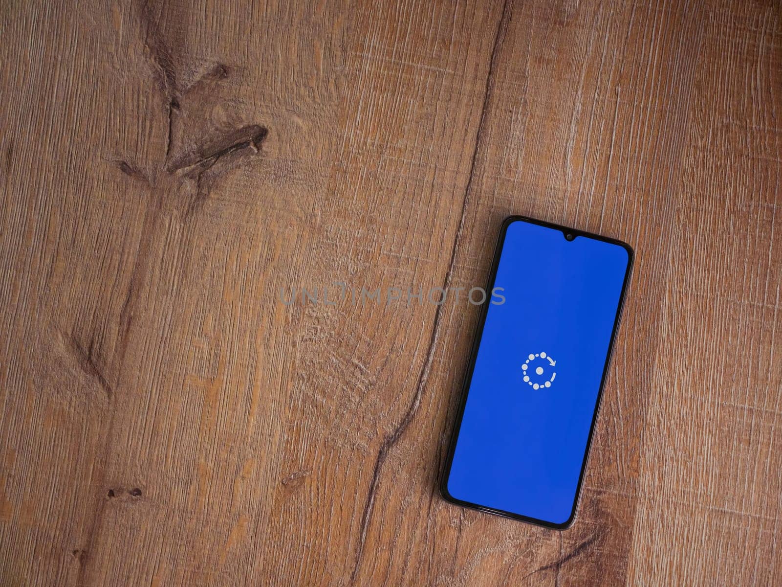 Lod, Israel - July 16,2023: Fing app launch screen on smartphone on wooden background. Top view flat lay with copy space.
