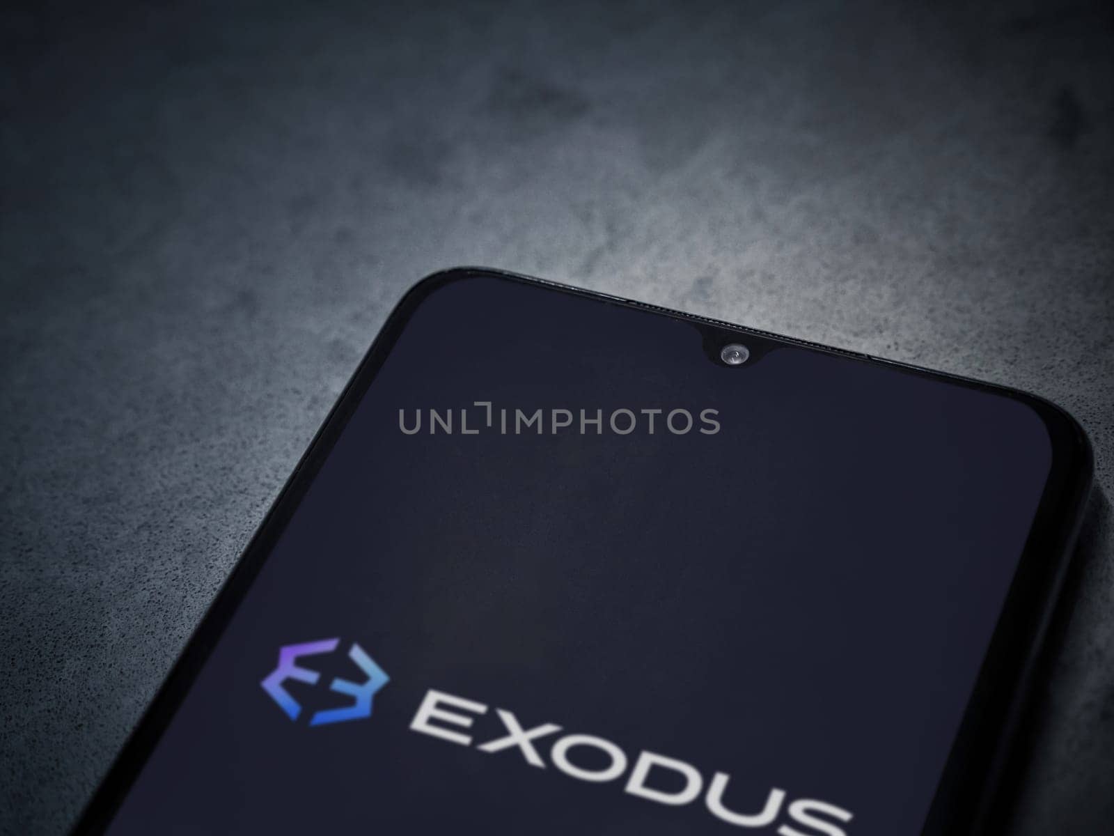 Lod, Israel - July 16,2023: Exodus app launch screen on smartphone on dark marble stone background. Top view flat lay with copy space.