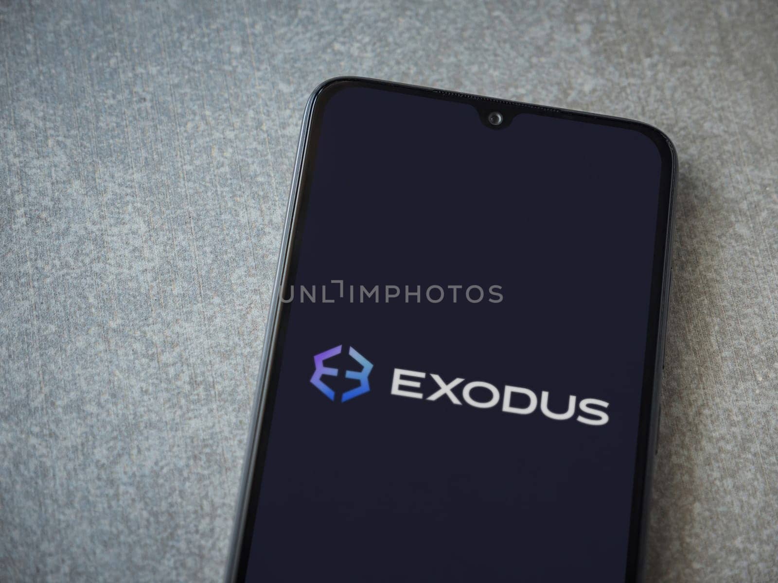 Lod, Israel - July 16,2023: Exodus app launch screen on smartphone on ceramic stone background. Top view flat lay with copy space.