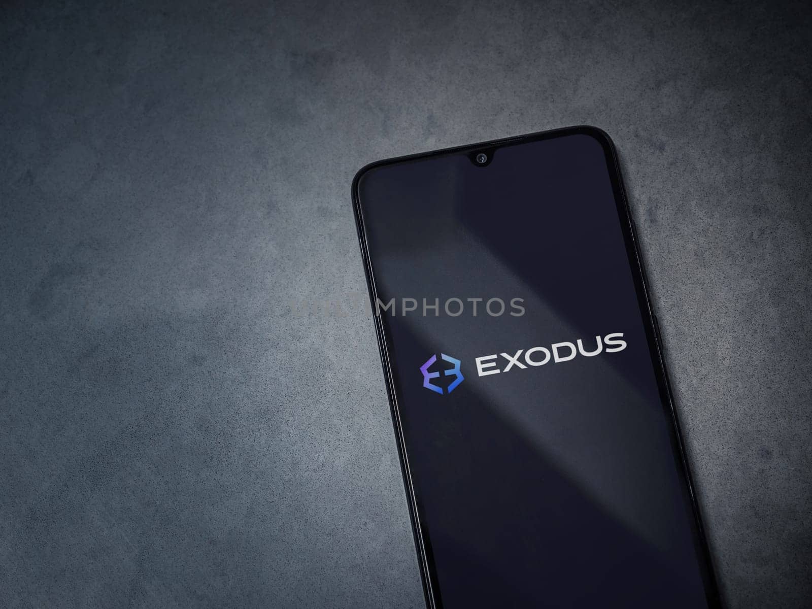 Lod, Israel - July 16,2023: Exodus app launch screen on smartphone on dark marble stone background. Top view flat lay with copy space.